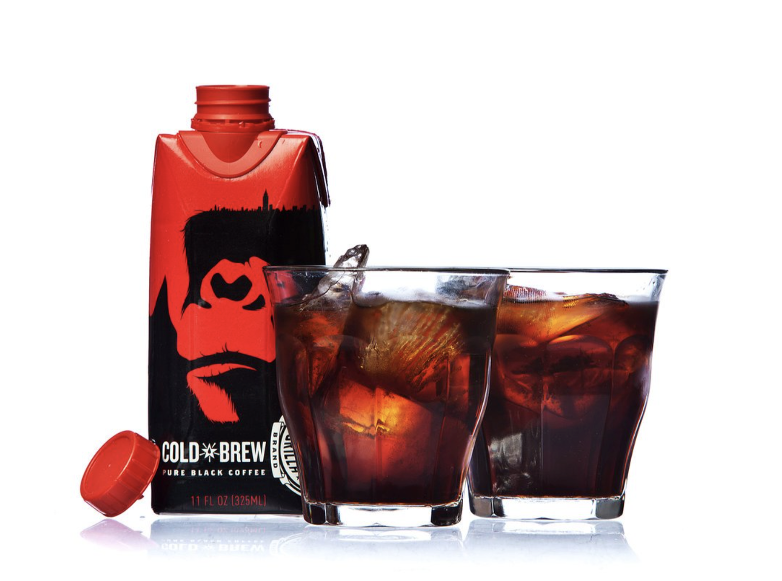 Cold brew coffee carton with gorilla design next to two glasses of iced coffee.