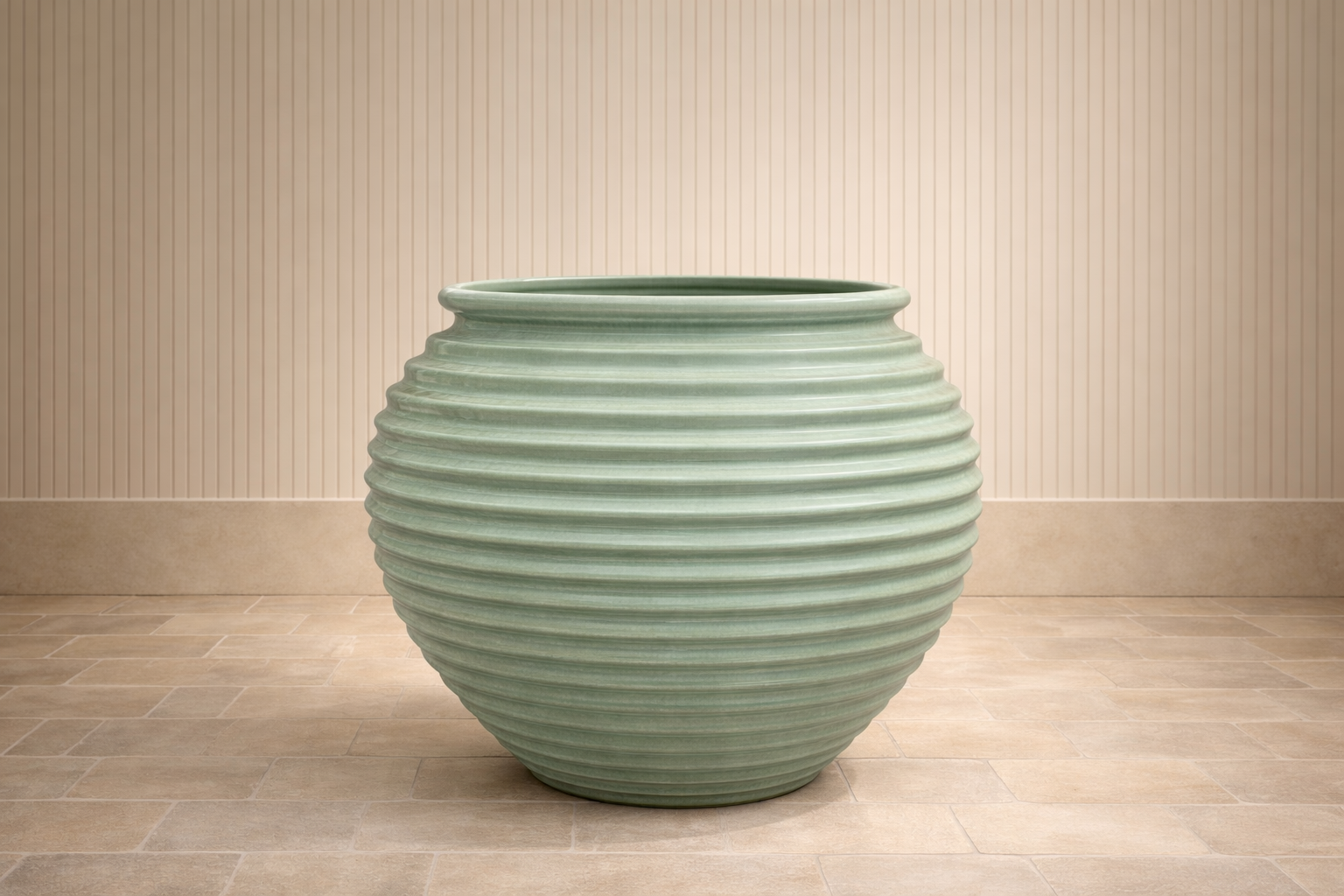 A large, rounded, striped ceramic vase with horizontal ridges, placed on a tiled floor against a vertically paneled wall.