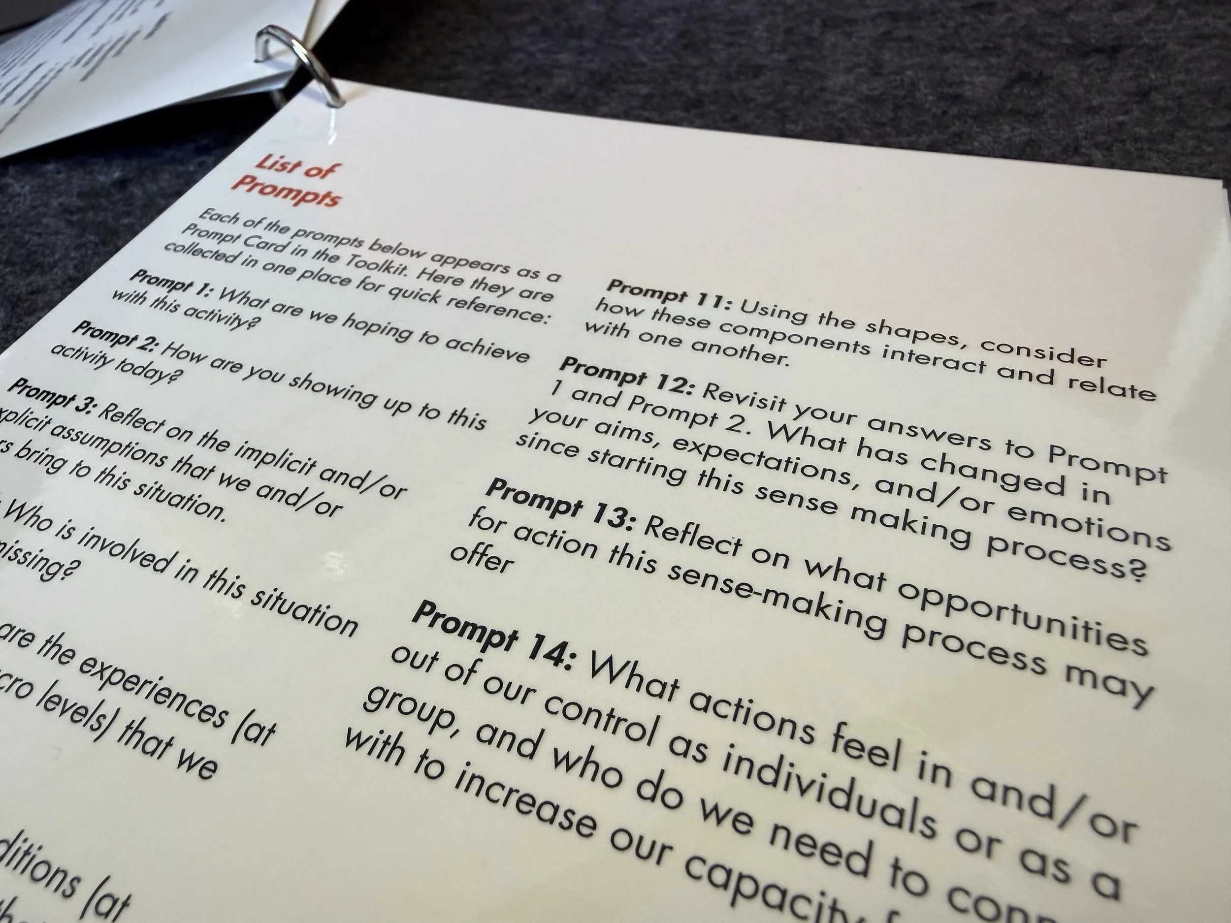 Close-up of a printed page titled 'List of Prompts' with numbered prompts on a dark surface.