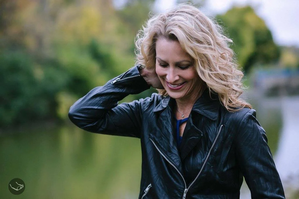 Jean Kiernan Detjen standing by the Fox River in Appleton, Wisconsin where she writes