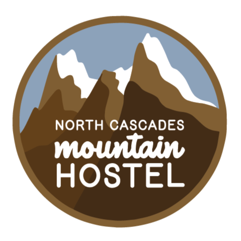 Graphic logo for North Cascades Mountain Hostel featuring stylized mountain peaks with snow and a circular border.