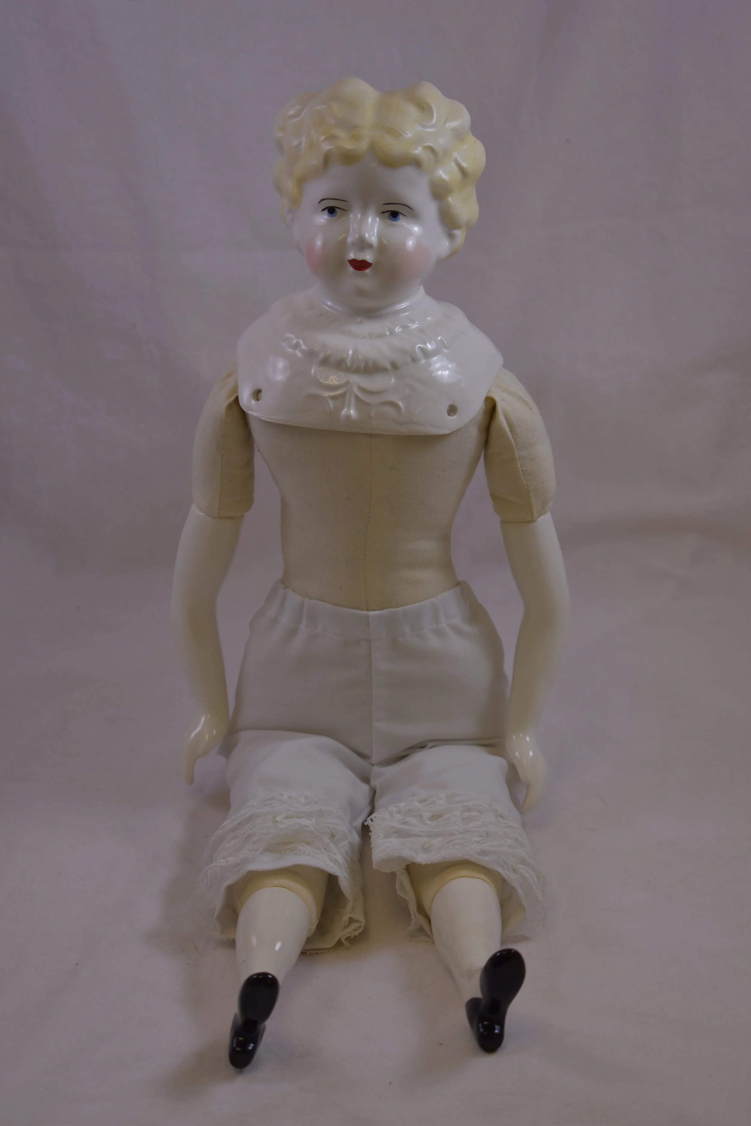 Doll with porcelain head and limbs.