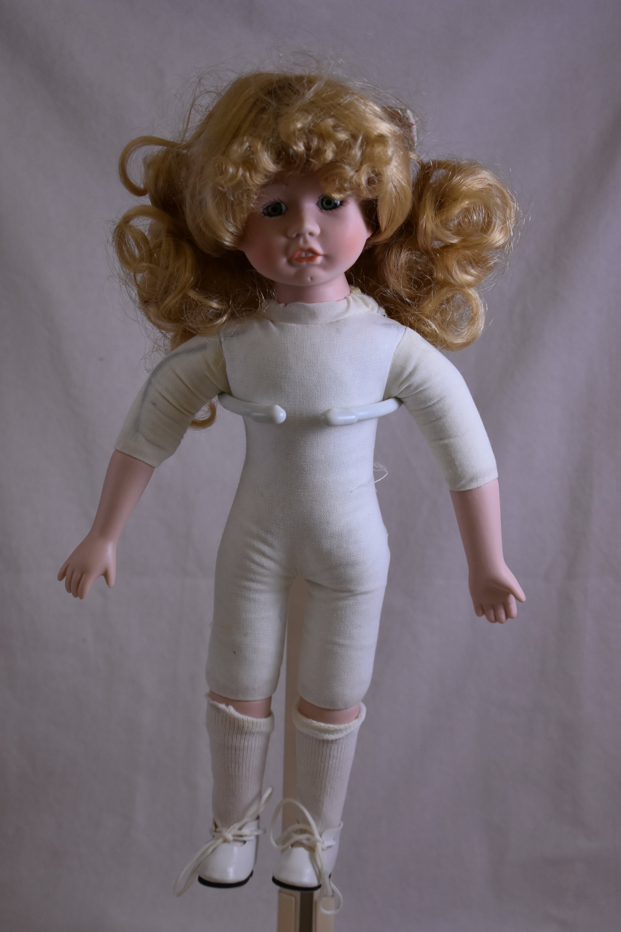 Cloth, stuffed body with composition arms and legs. 