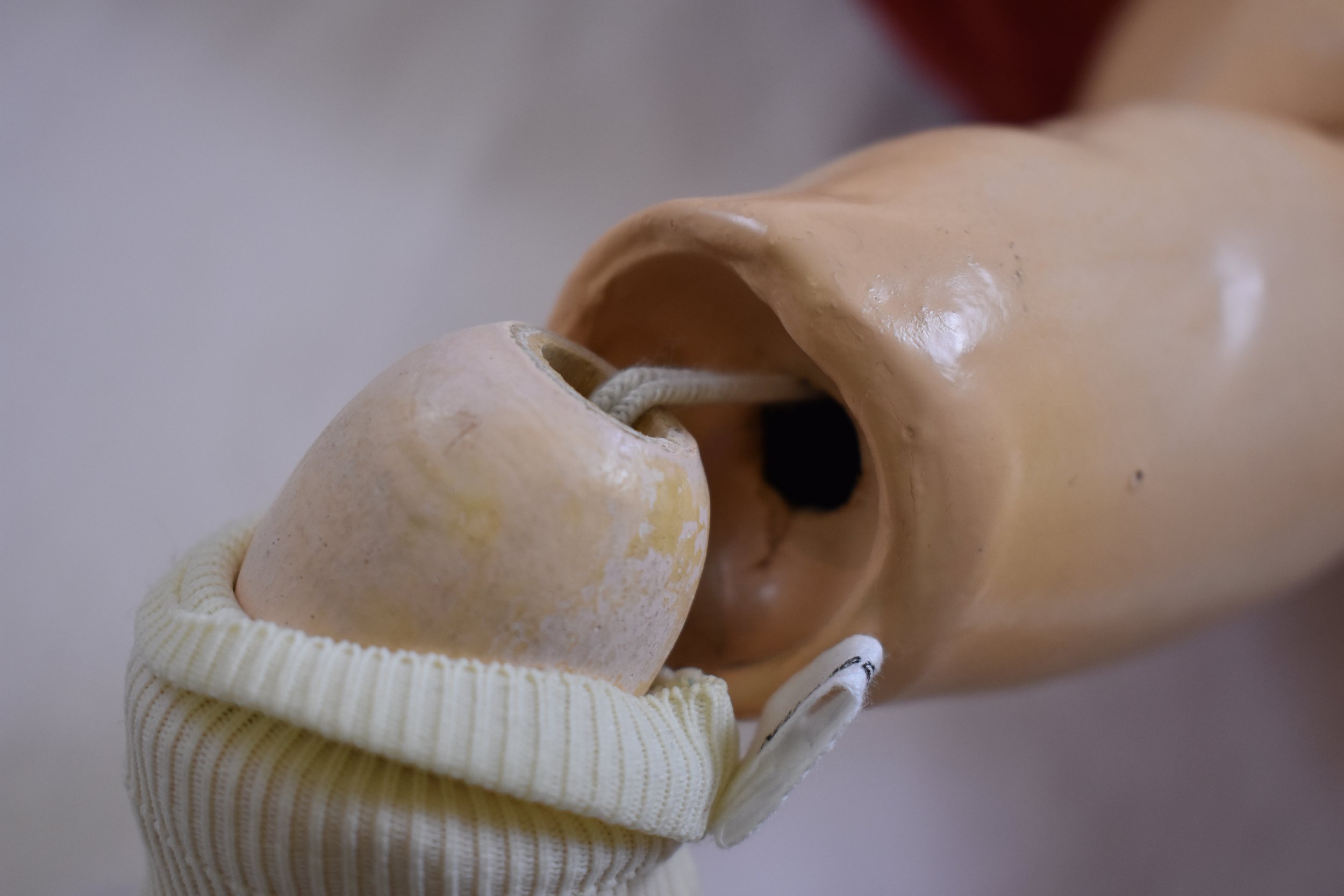 Socket knee joint with elastic ligature