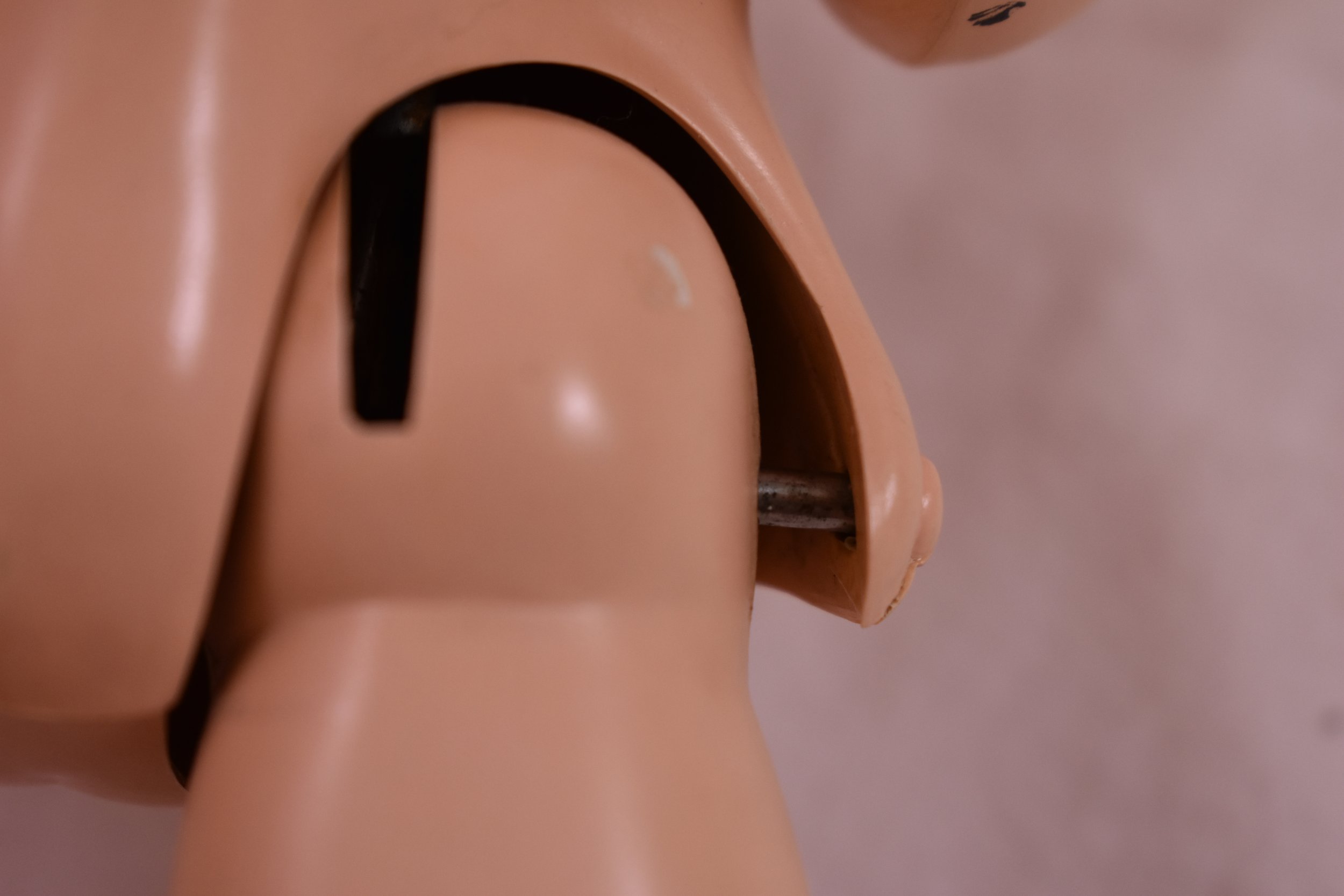 Metal hinged leg on a walking doll.