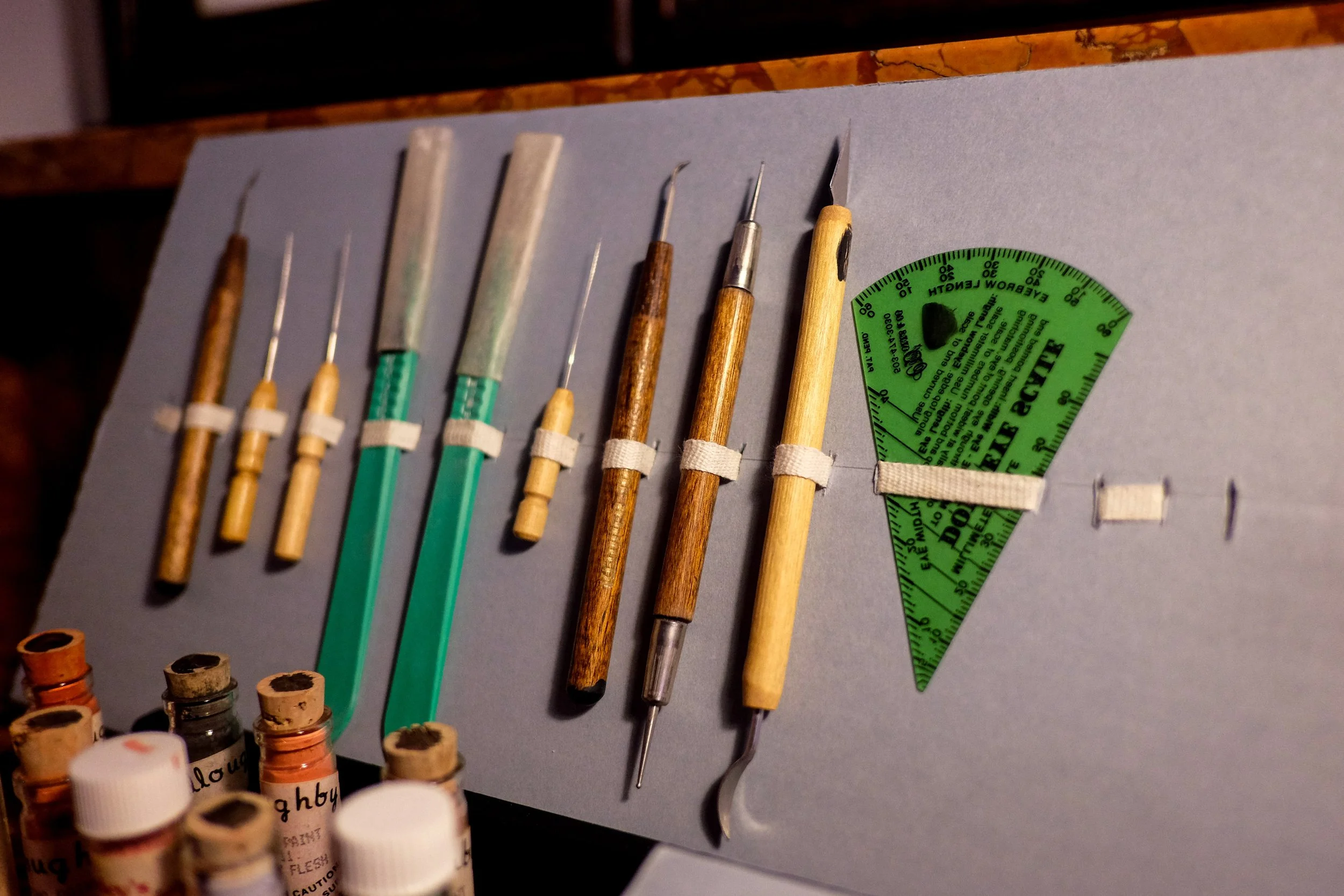 A set of tools, including scrapers, knives, and texture tools used for making and molding porcelain dolls.