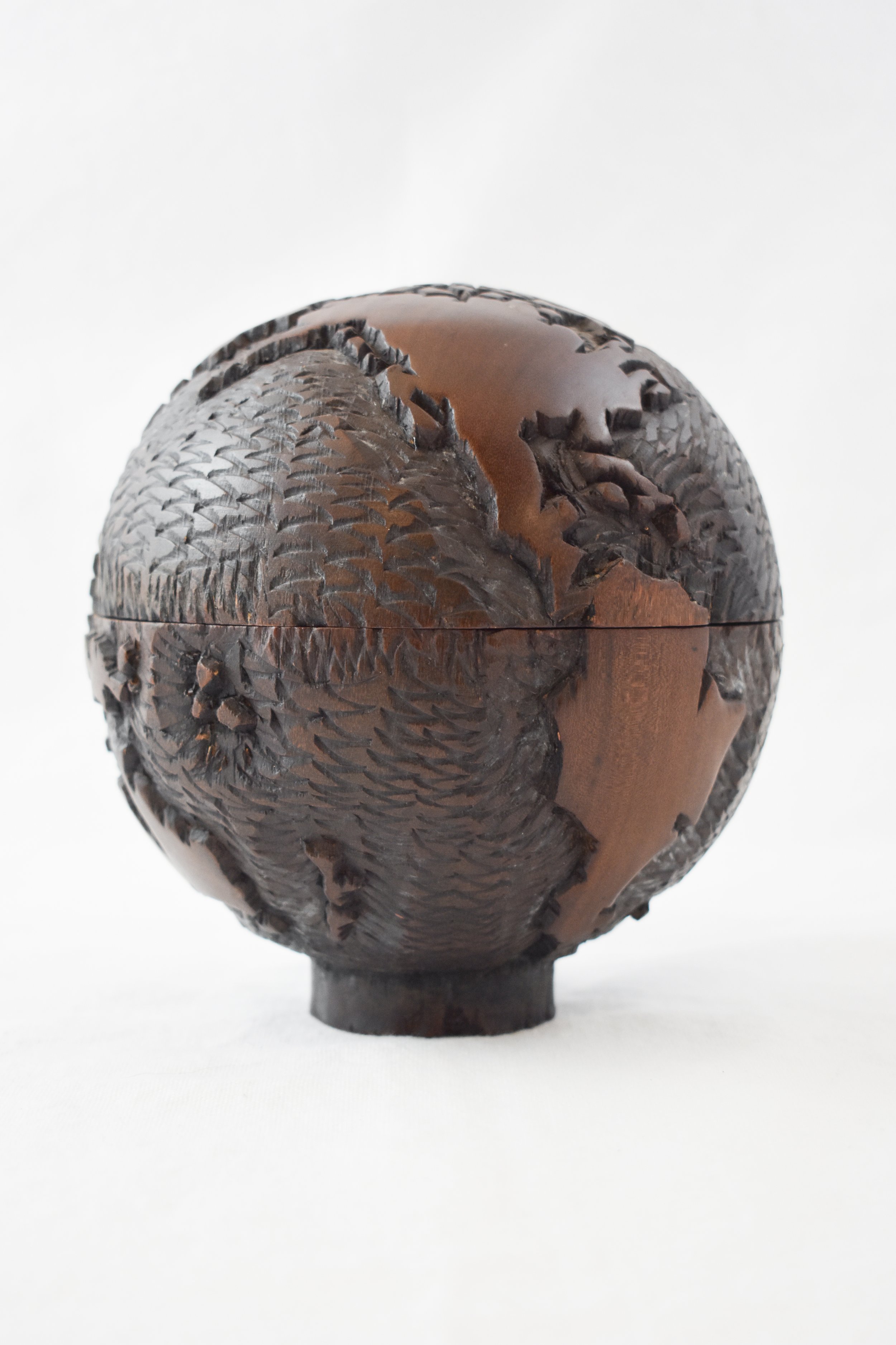 A small wood carving of a globe, highlighting the carving skills of the Shona people. Although mostly known for their stone carvings, the Shona people have begun carving wood to make goods to sell to tourists. The globe is most likely made from mukwa