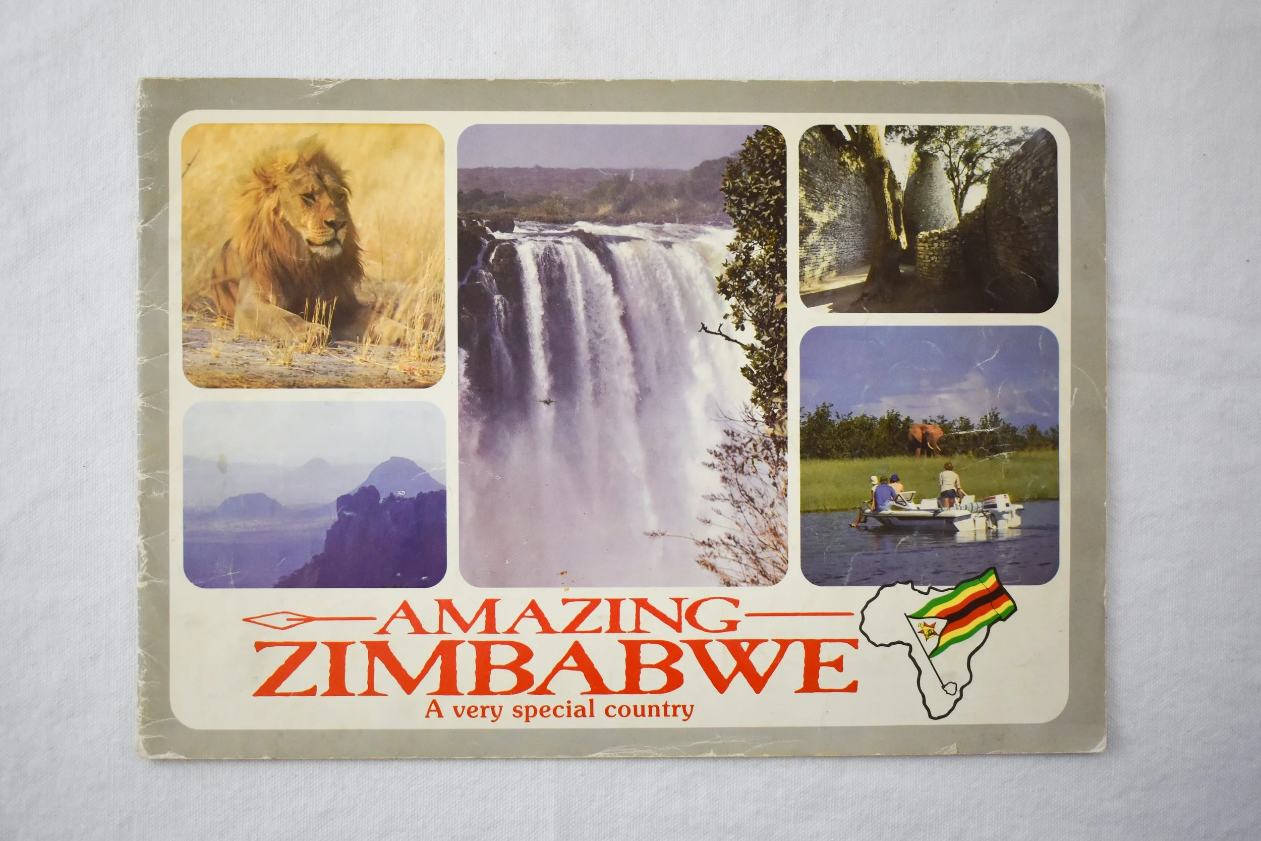 Cover of a promotional/tourism book published by the Zimbabwe Tourism Board. It displays some of Zimbabwe’s natural attractions, such as Victoria Falls, wildlife, the Eastern Highlands, the ruins of Great Zimbabwe, and the Zambezi River.