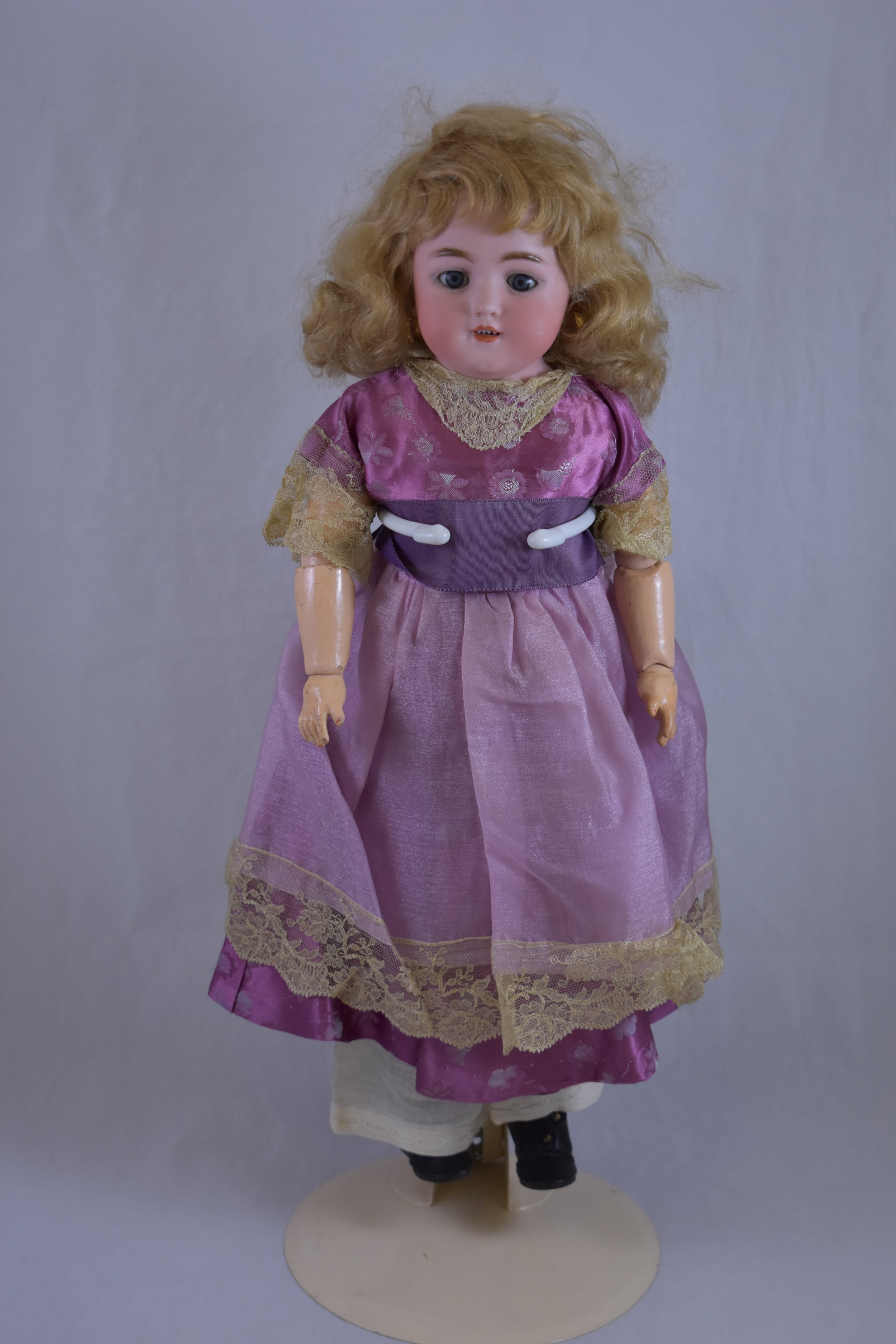 This Simon & Halbig doll has a bisque head, a pink, kid leather body and composition lower arms and legs. 