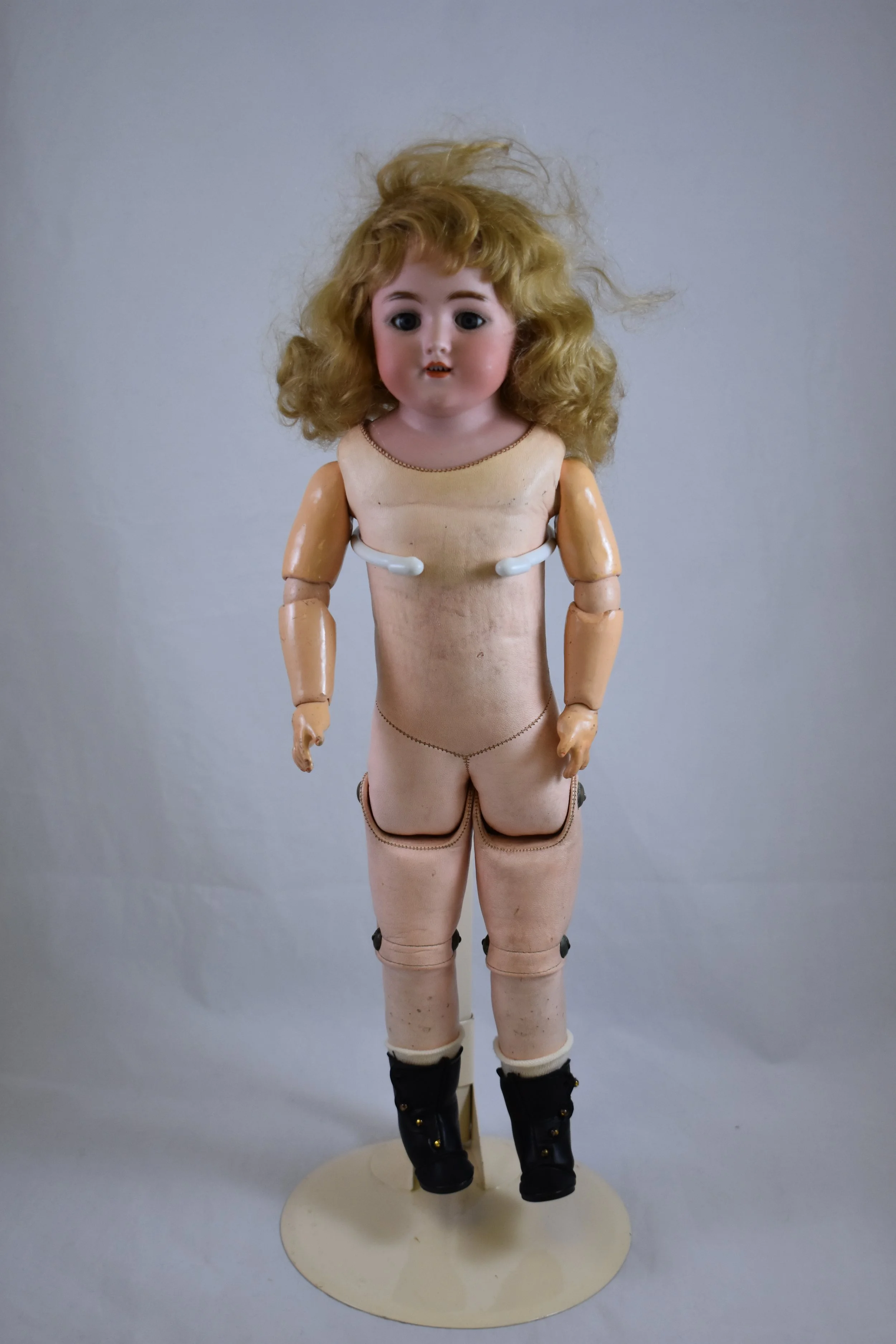 This Simon & Halbig doll has a bisque head, a pink, kid leather body and composition lower arms and legs. 