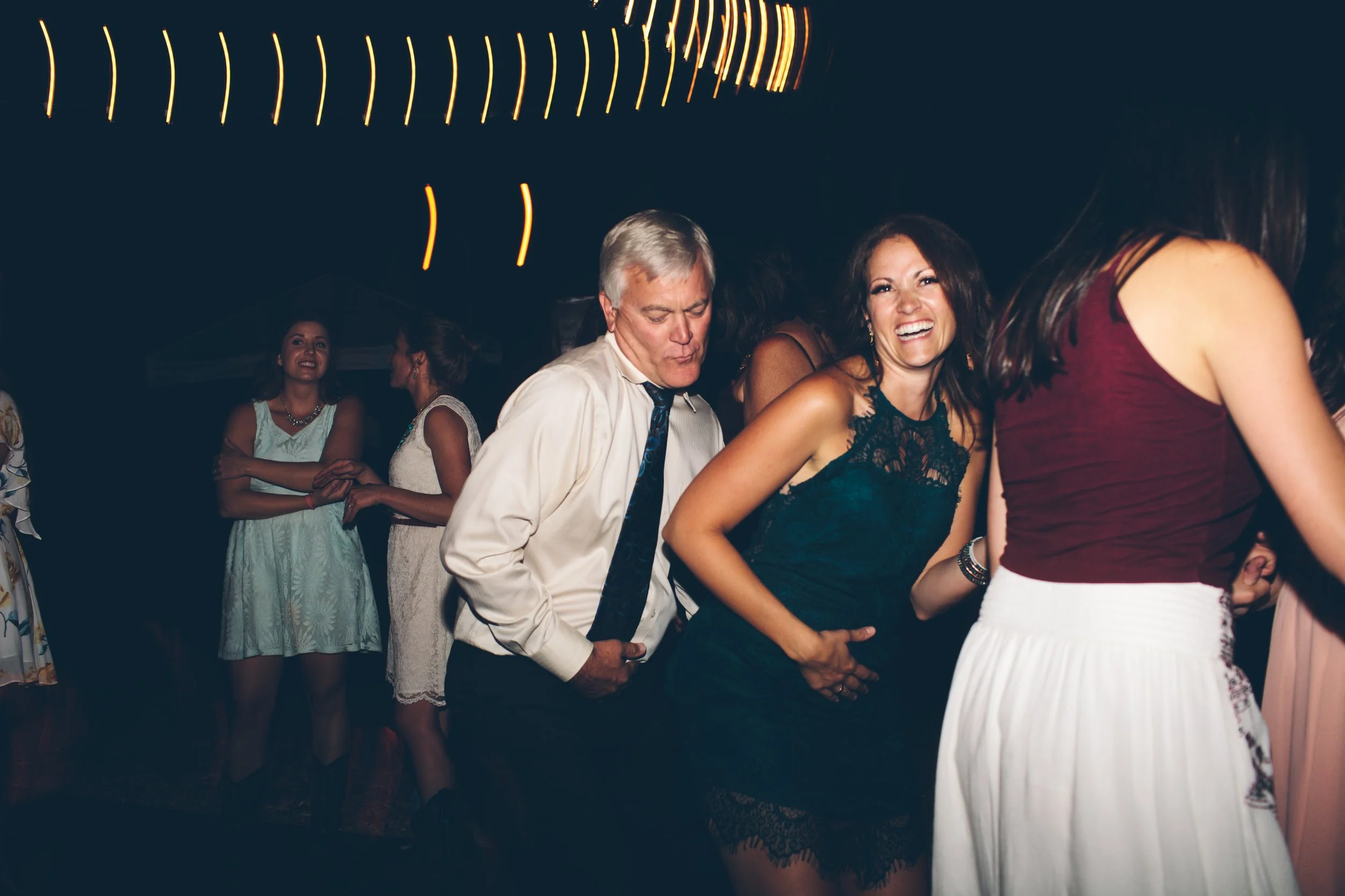 People dancing at a party, laughing, and having fun.