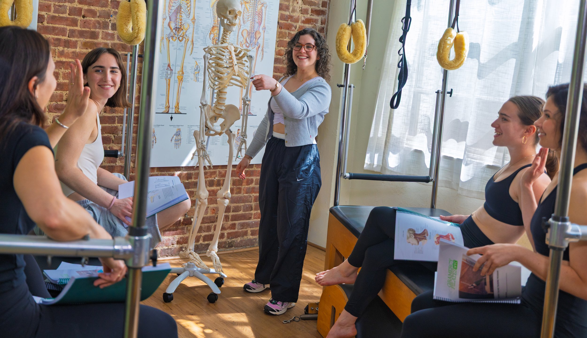 Instructor guiding students during Pilates Certification class
