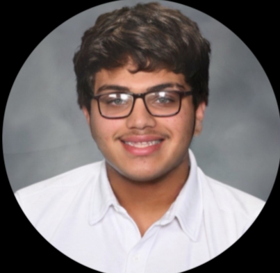 A young man with glasses smiling in a professional headshot.