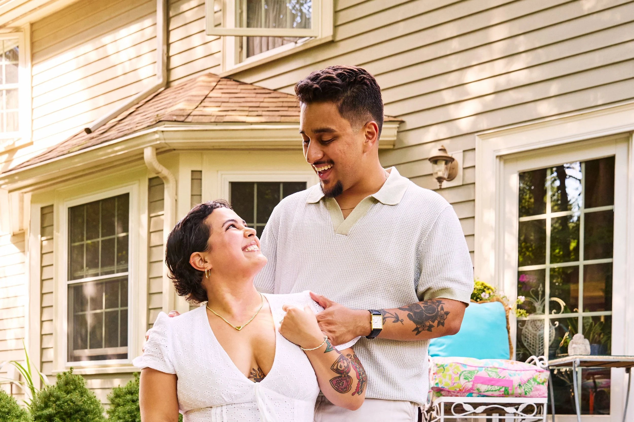 Laurie’s customers, Mariana and Carmen holding hands on a green lawn on their wedding day.