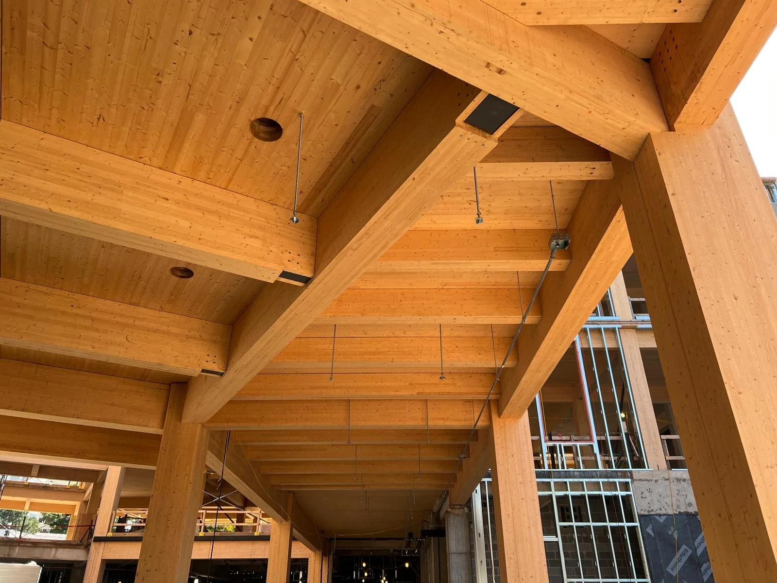 Construction site with large wooden beams and framework for a building under construction.
