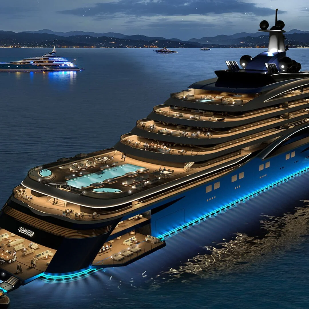 A large luxury cruise ship illuminated at night with multiple decks, swimming pools, and outdoor lounging areas, sailing on calm water with other ships and mountain in the background.