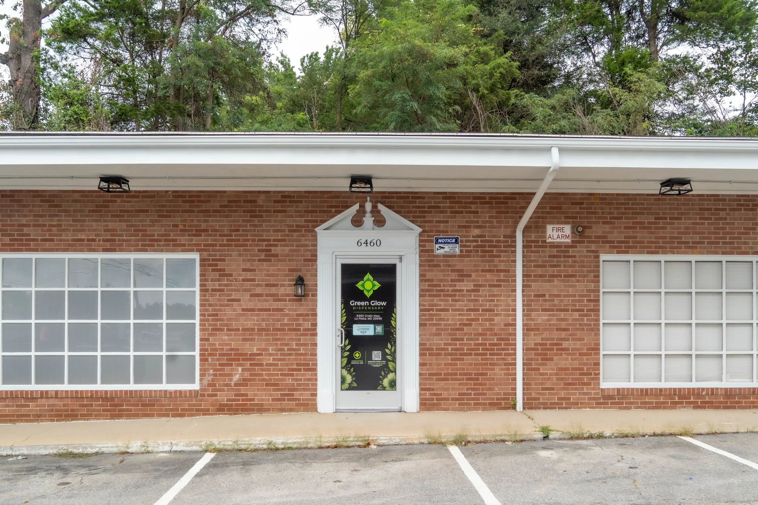 Looking Directly at the Green Glow Store Front facing the Front Door which has the Logo and Store Information.