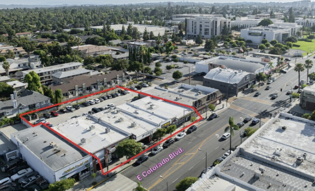 Aerial view of a commercial lot outlined in red, located on E Colorado Blvd, surrounded by various buildings and streets in an urban area.