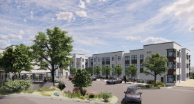 Modern residential apartment complex with parking lot, trees, and landscaped areas.