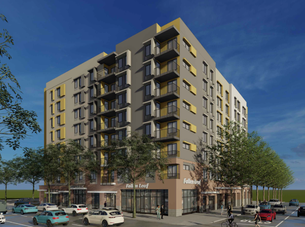 A multi-story modern apartment building with commercial spaces on the ground floor, surrounded by trees and parked cars, under a blue sky.