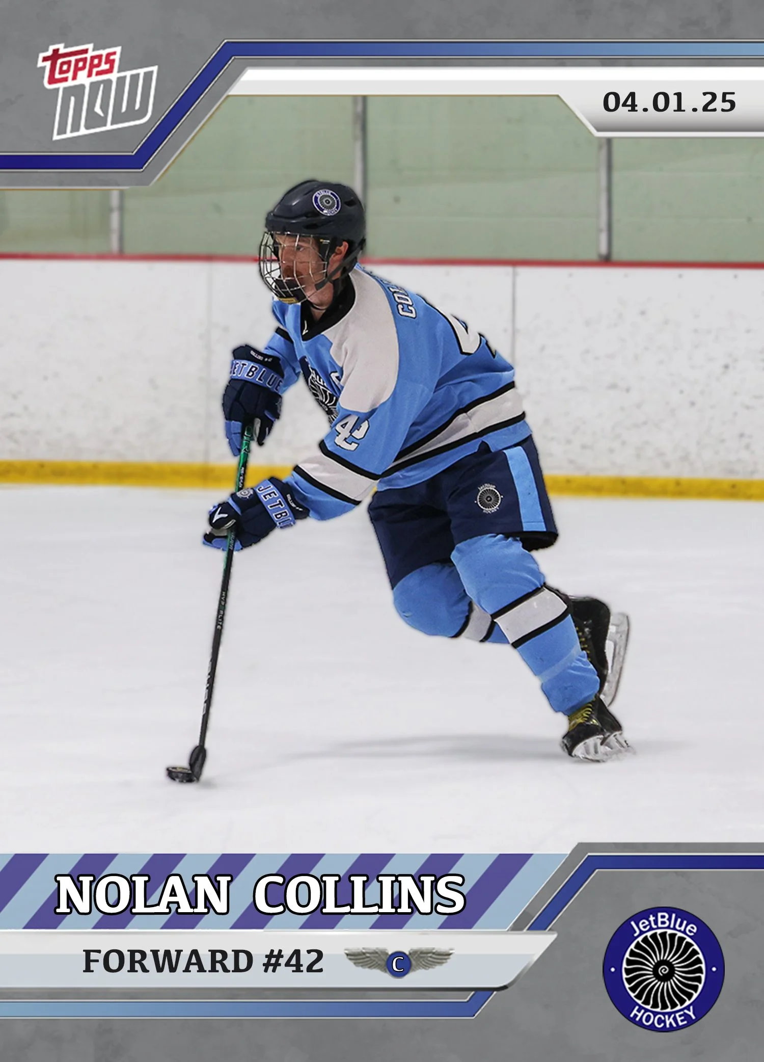 A hockey player wearing a blue and white jersey with the number 42, skating on ice with a hockey stick, at an indoor ice rink.