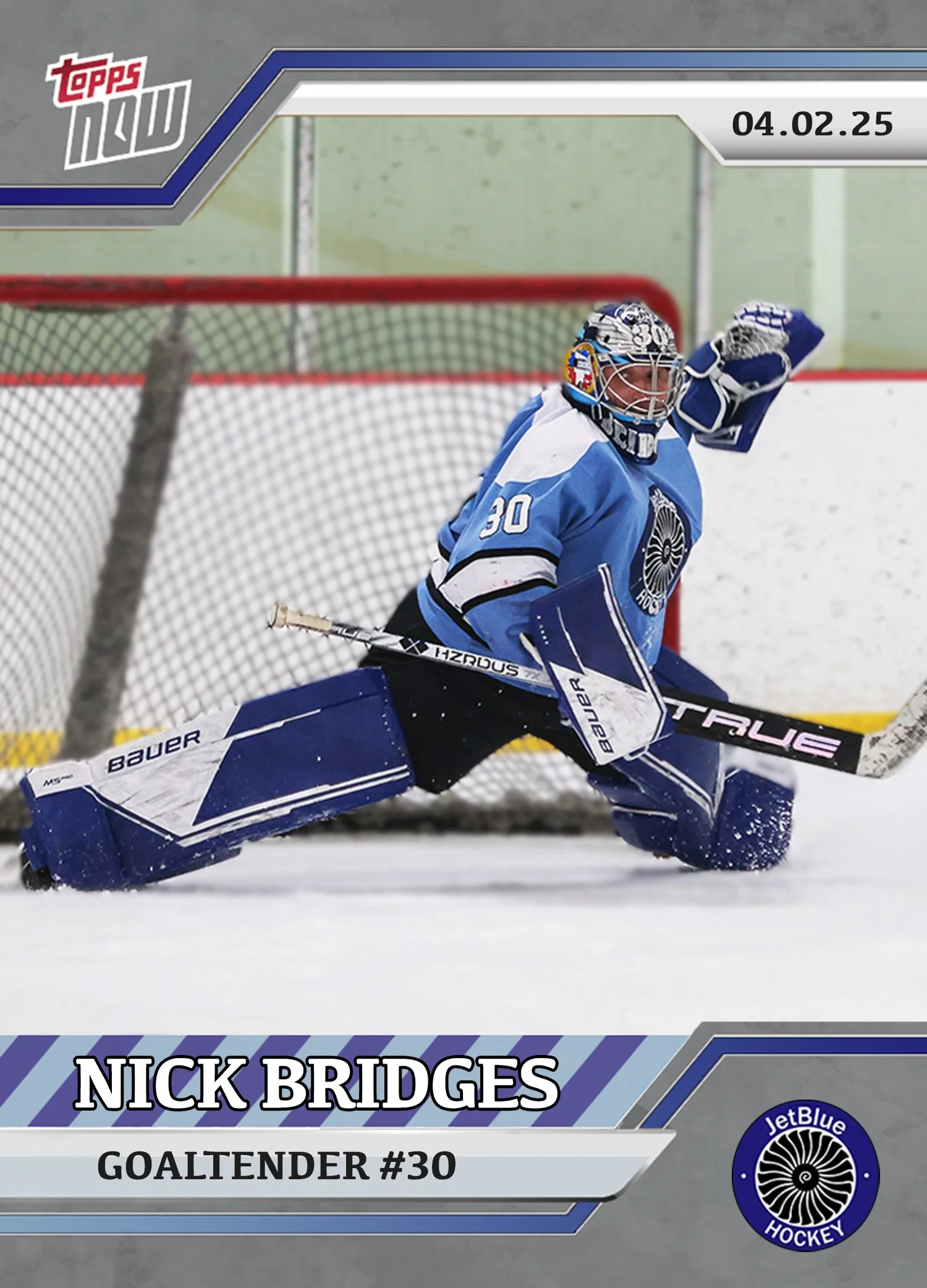 Hockey goaltender in blue gear is making a save in front of the goal, dressed in full protective equipment including pads, gloves, and a mask, on an ice rink with a net and boards in the background.