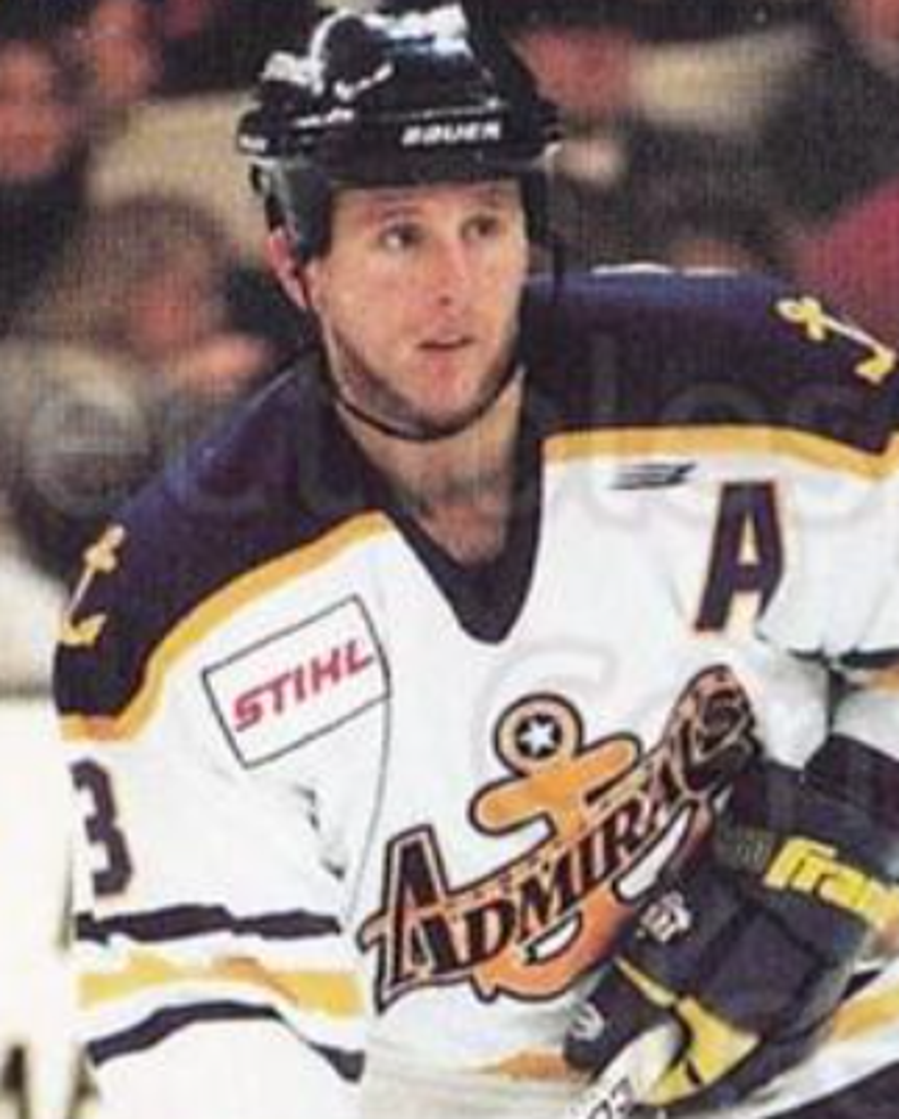 Hockey player in a jersey with the number 3 and 'Admirals' logo, wearing a helmet, on ice during a game.