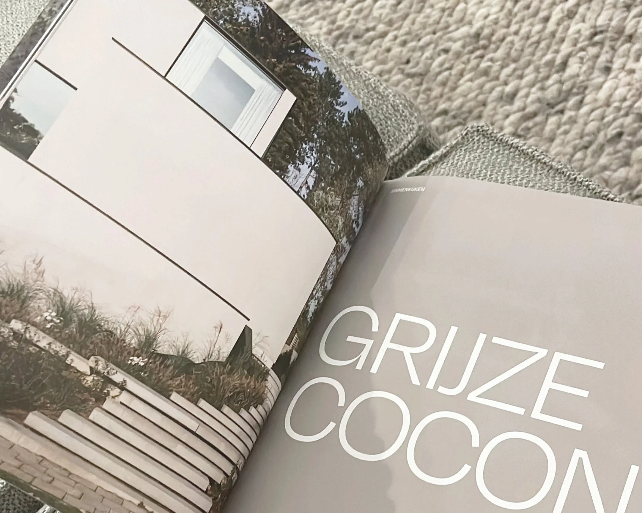 Livre ouvert avec une image de paysage extérieur, comprenant des arbres et un ciel, sur une surface avec du texte en arrière-plan.