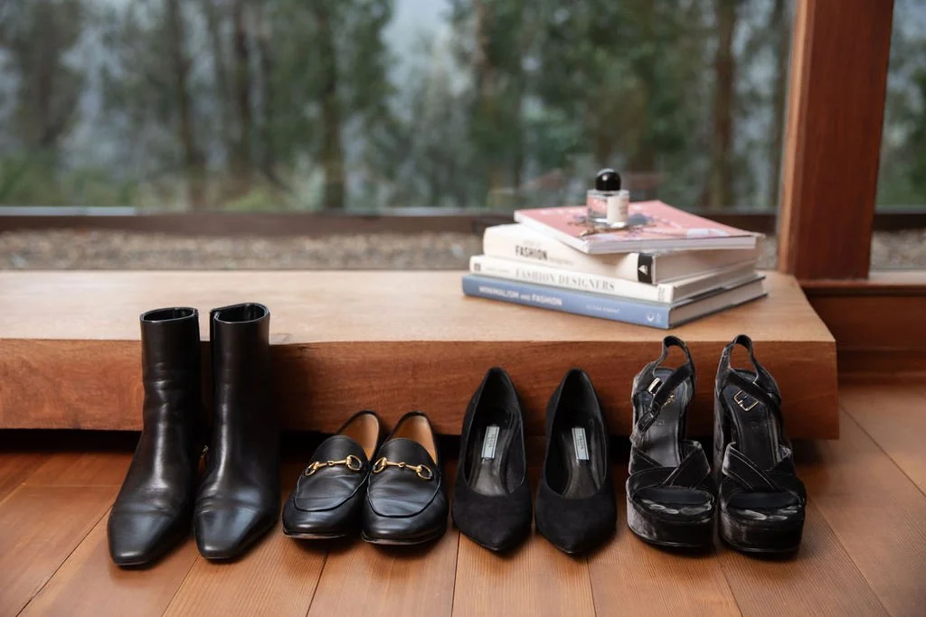 Assortment of black shoes styled in a line.