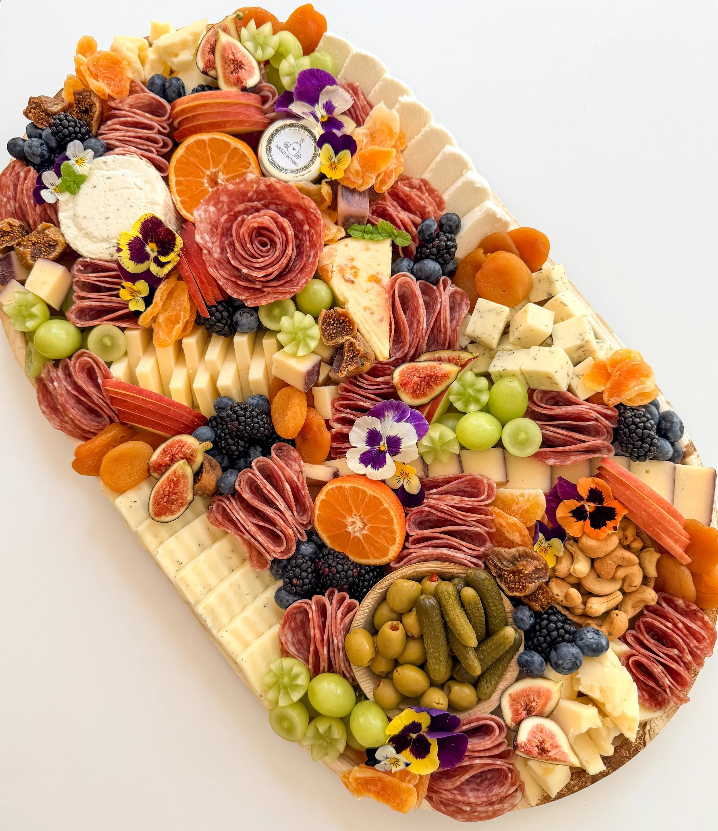 Cheese and fruit platter with flowers and a 'happy birthday' sign.