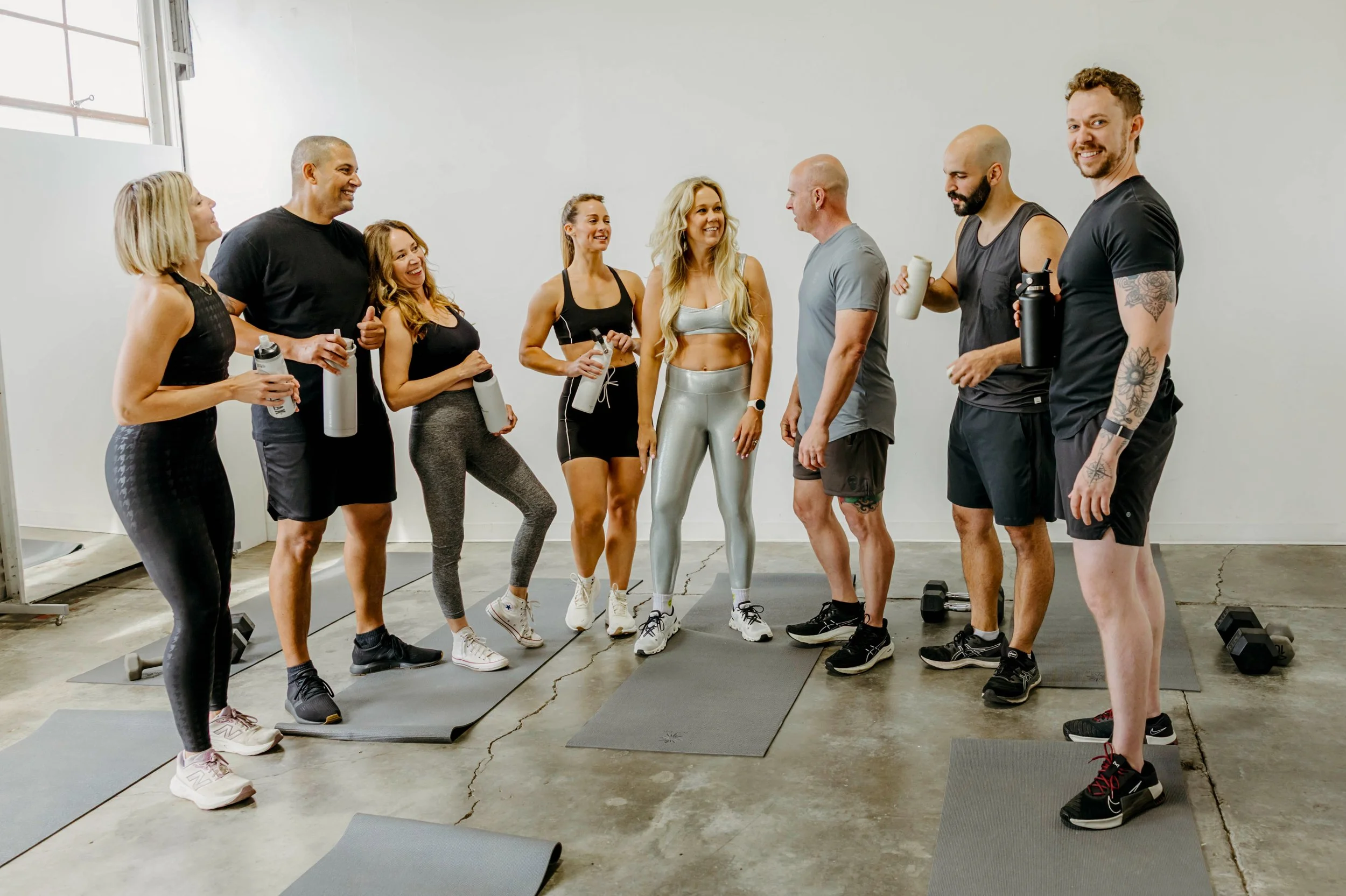 Group of people talking after workout and drinking water.