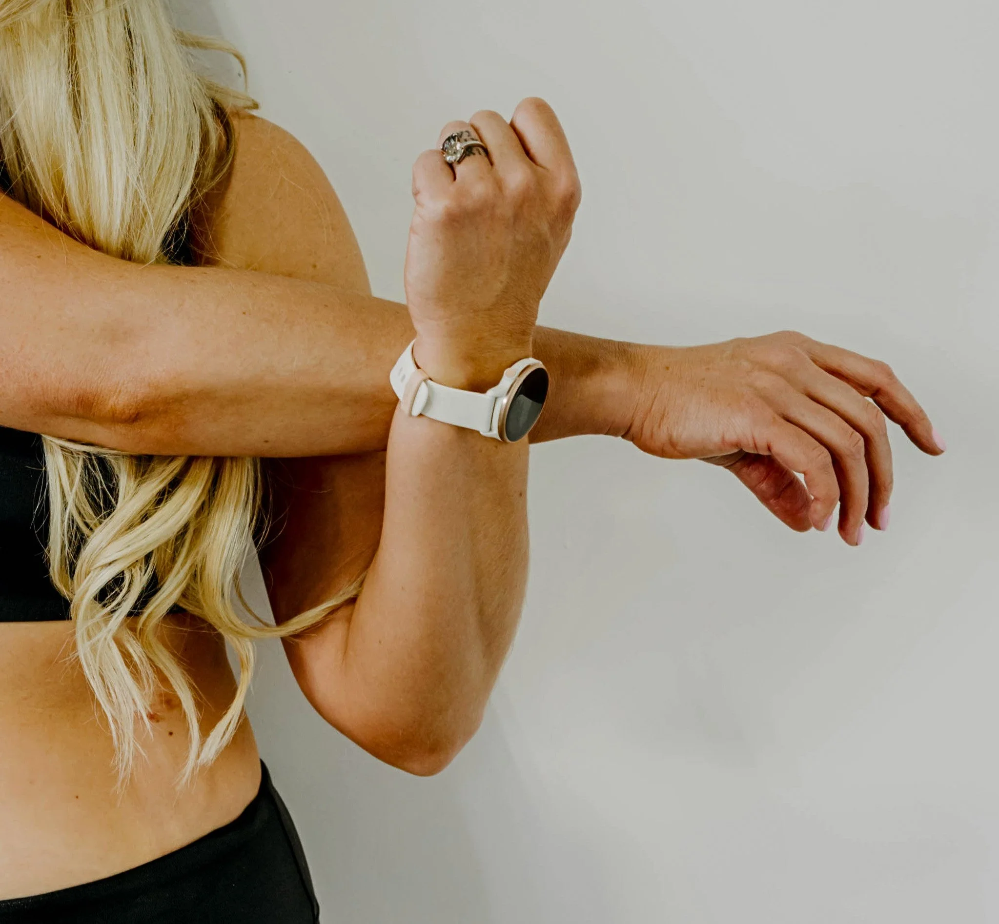 Woman crossing arm over chest to stretch.