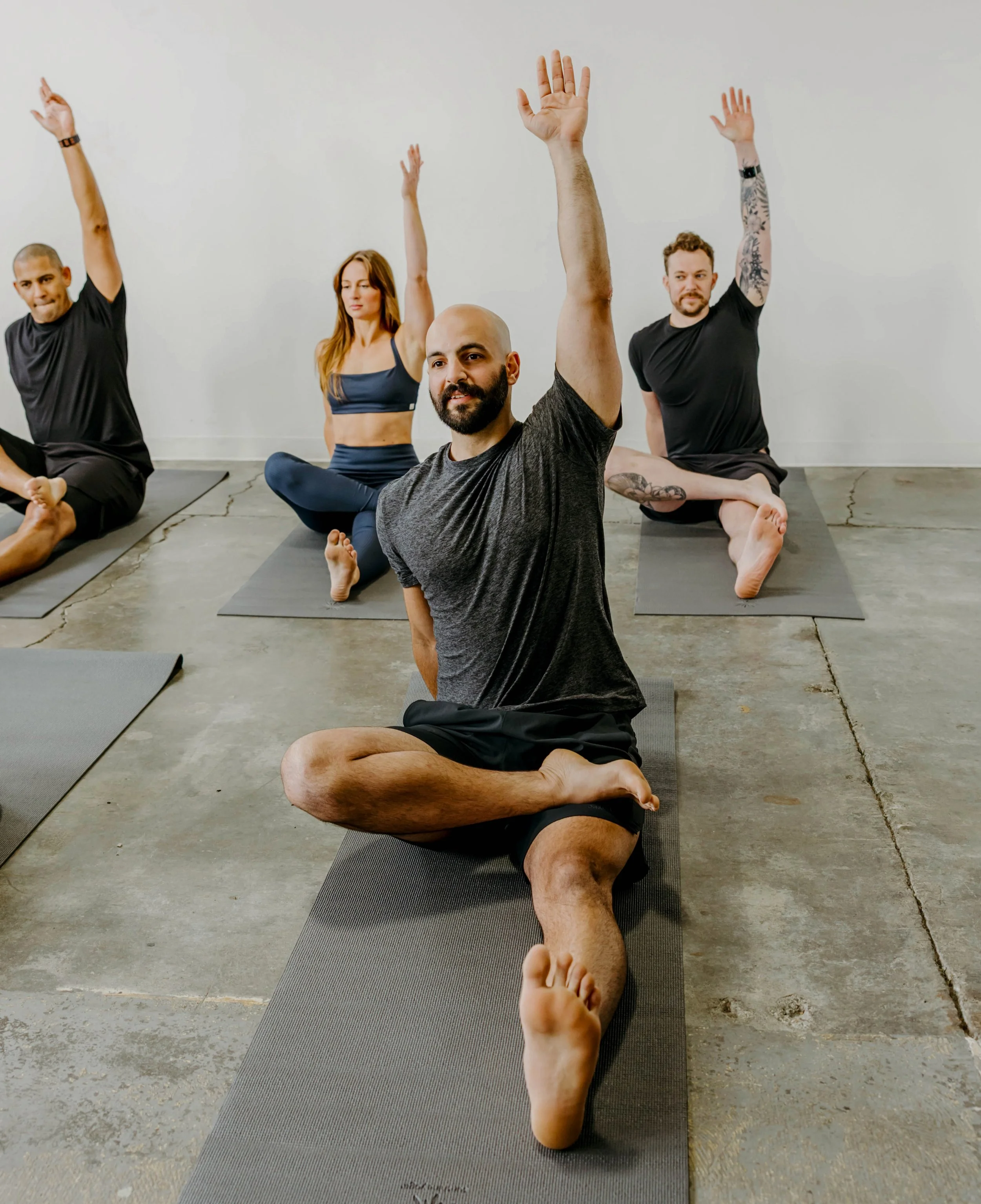 Group stretching on the ground on yoga mats.