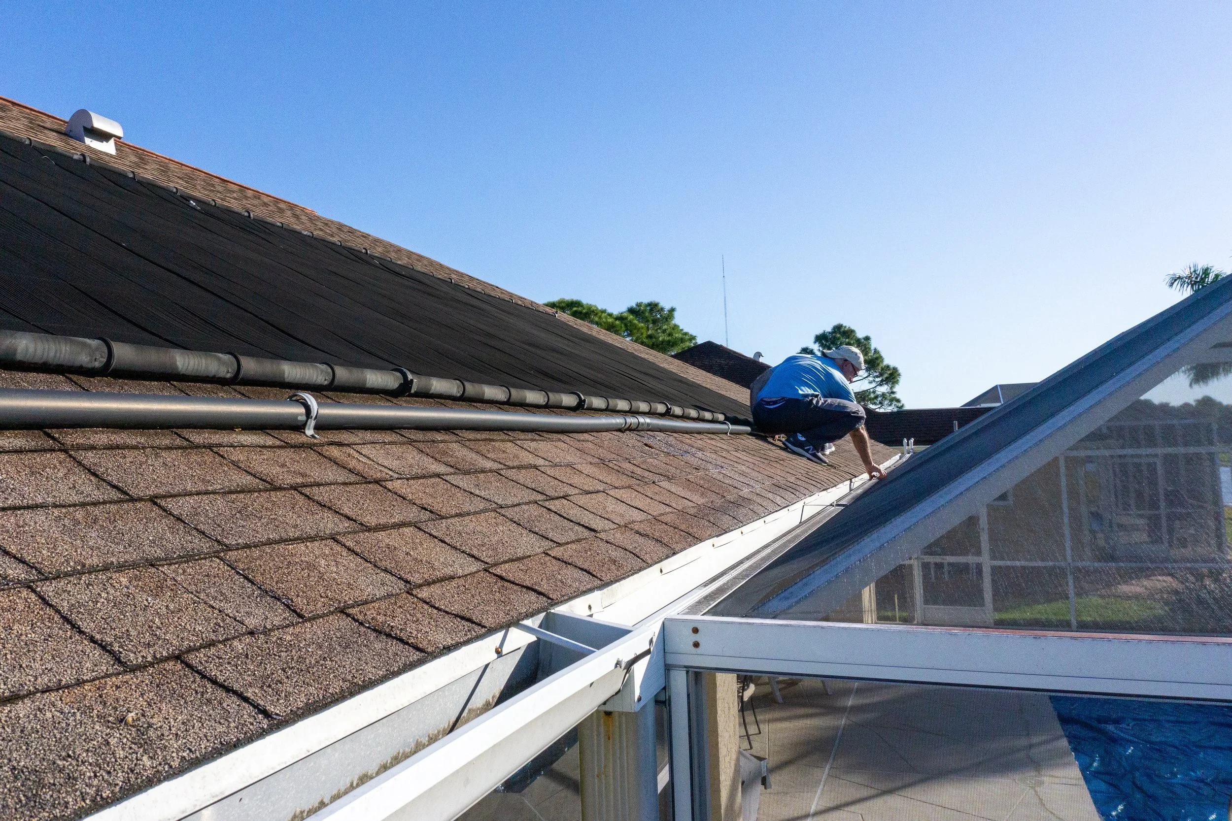 Man looking at shingles and gutters on a roof