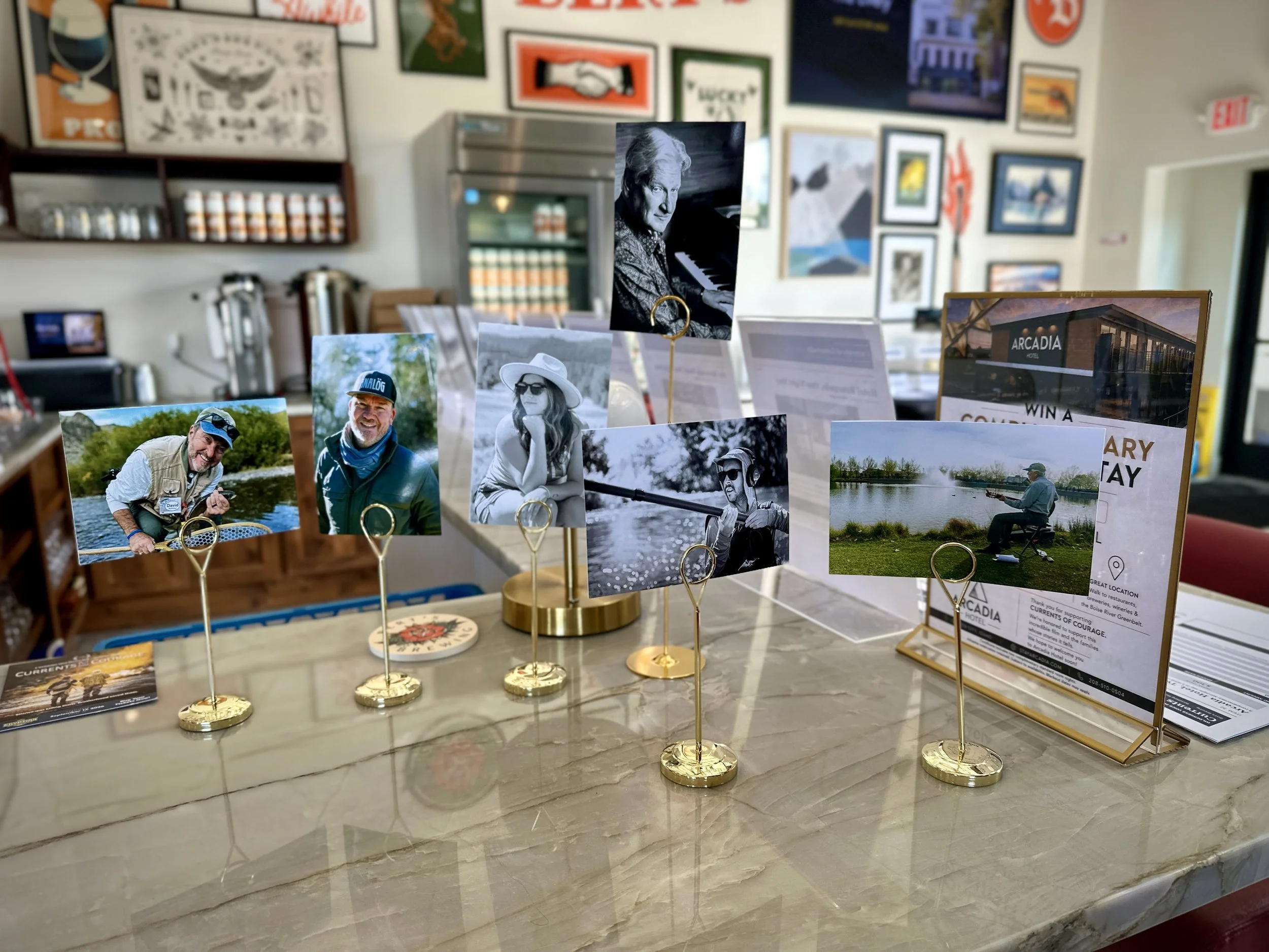 Display of small photographs featuring people, including a man in a hat, a woman with sunglasses, and a man fishing by a lake.