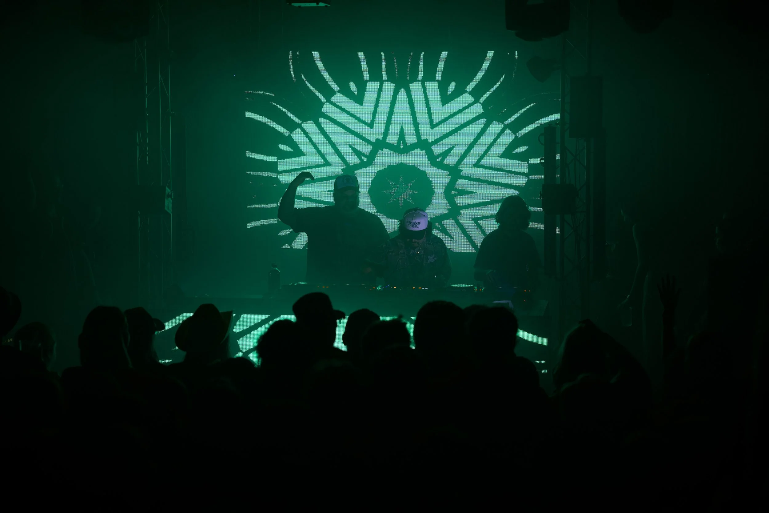Modern wooden building with large glass window, set against a backdrop of mountainous terrain.