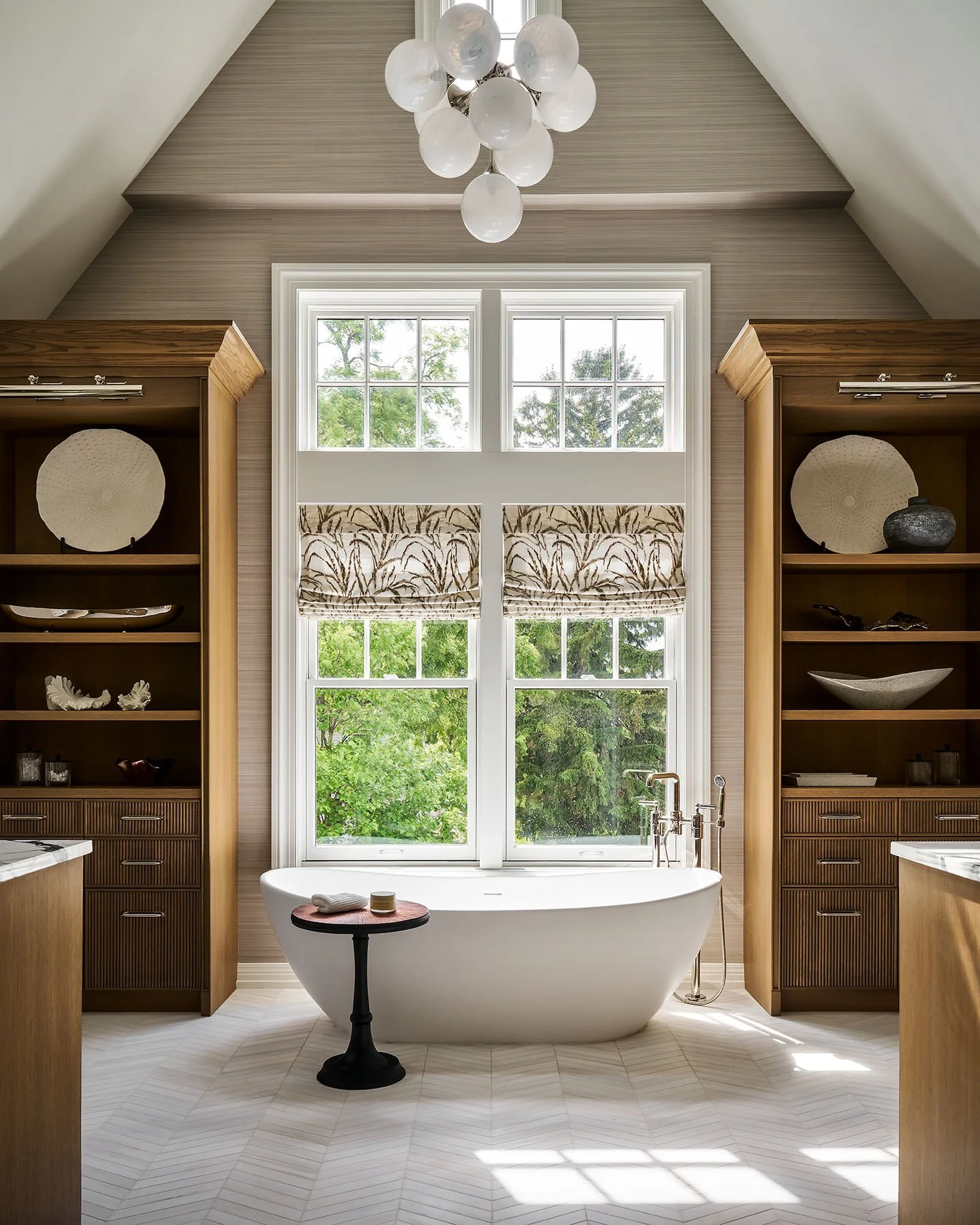 Luxury primary bathroom with freestanding tub, custom wood cabinetry, and vaulted ceiling in Kenilworth residence.