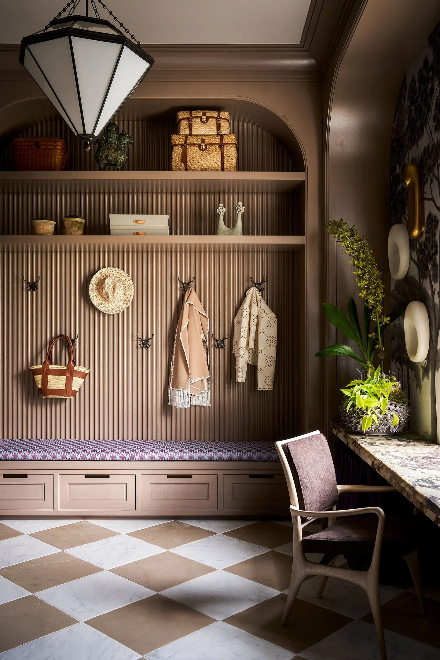 Luxury mudroom storage with arched millwork, integrated bench, decorative shelving, and neutral-toned cabinetry.