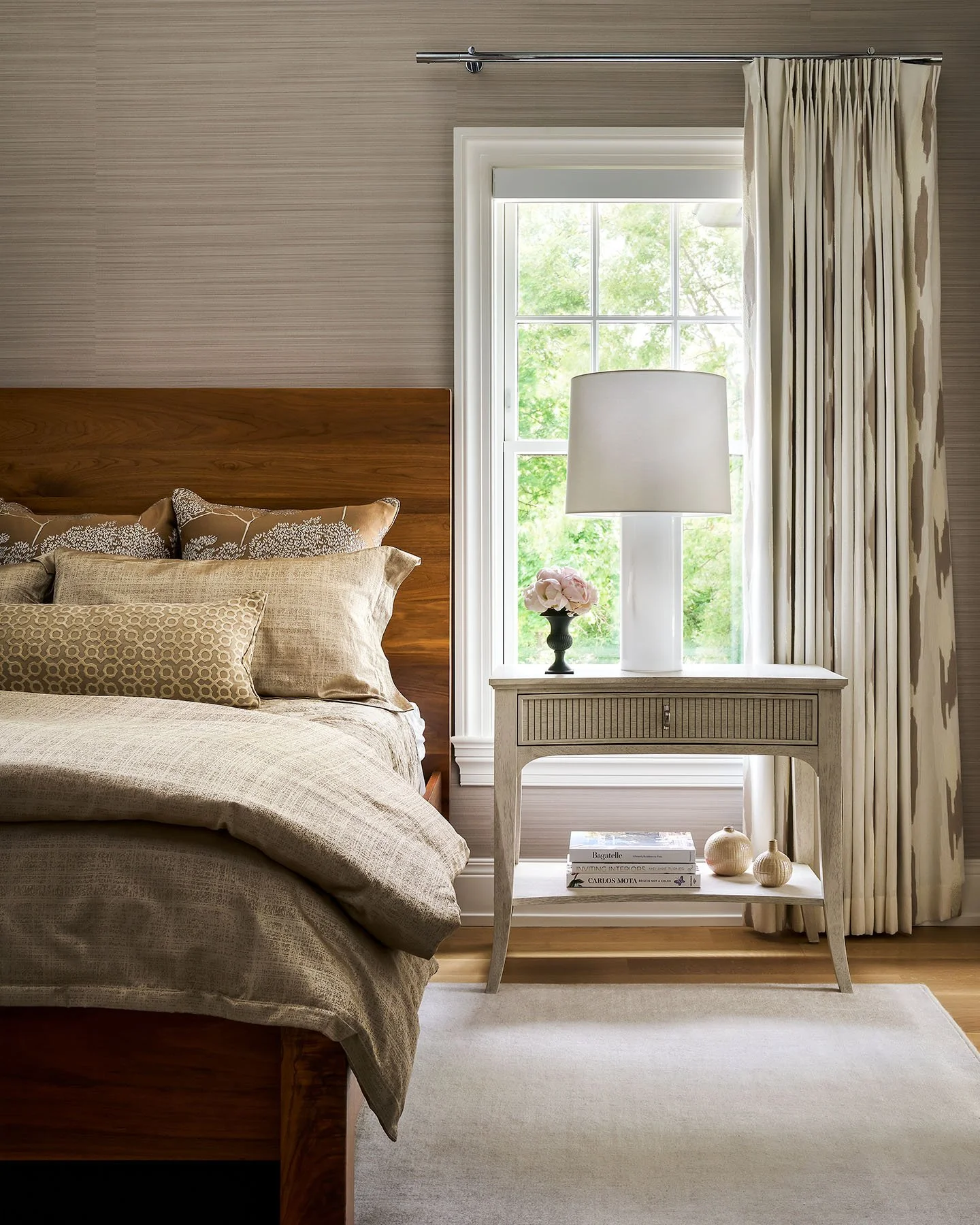 Primary bedroom with wood bed frame, neutral textiles, and custom drapery in Kenilworth interior design project.