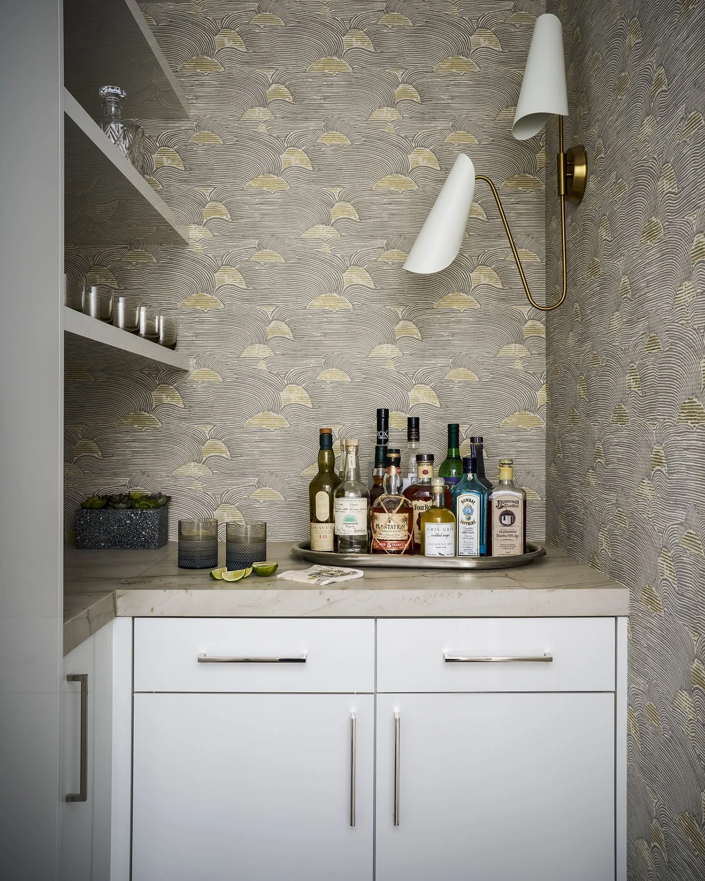 Luxury powder room with floating stone vanity, brass sconces, and textured wallcovering in Kenilworth home by Jen Marie Interiors.