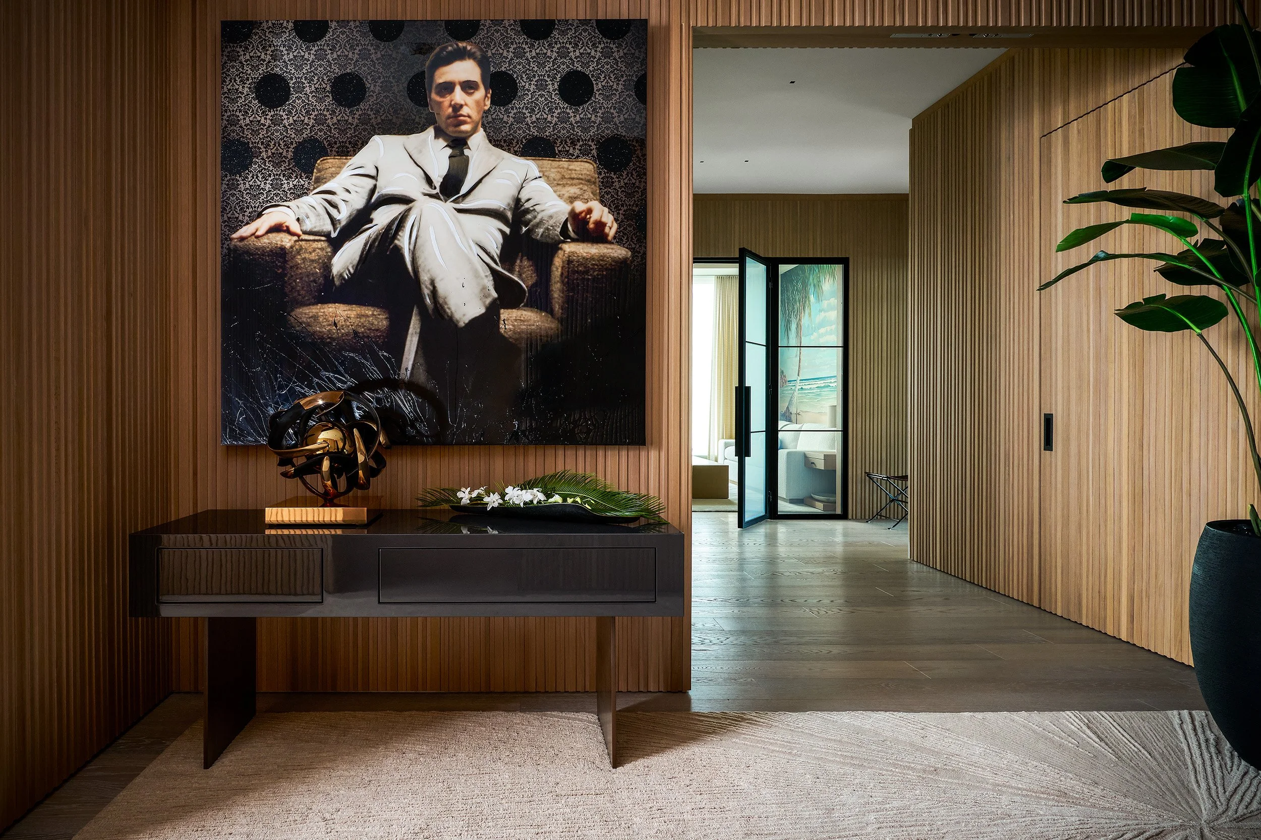 Modern entry hallway with wood slat walls, console table, and framed portrait artwork