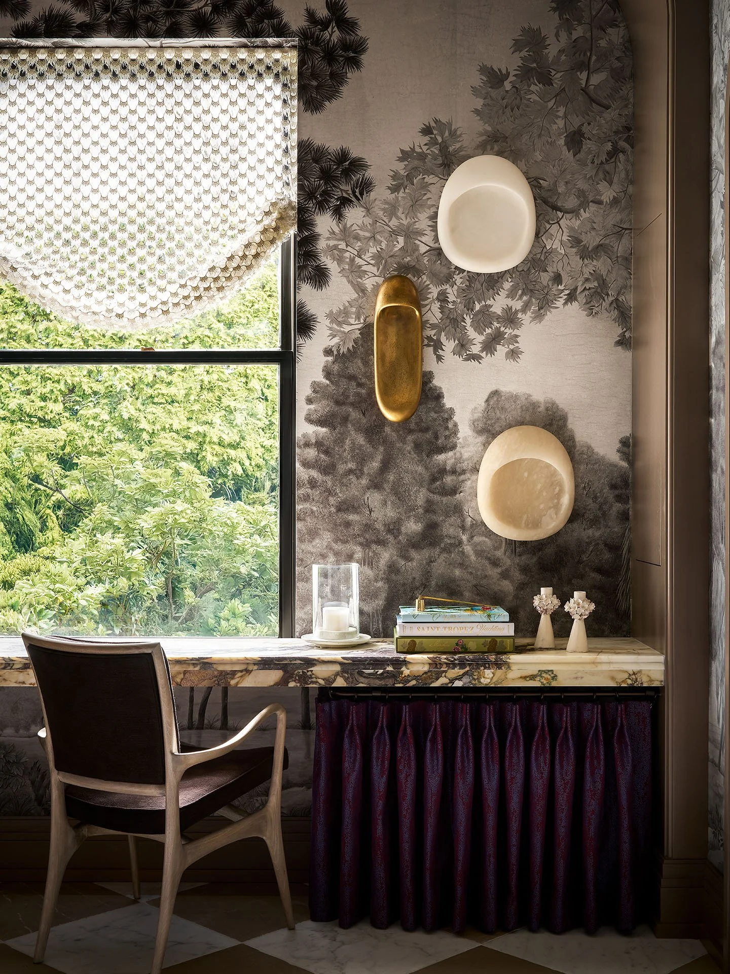 Custom built-in desk with marble surface, botanical mural wallpaper, sculptural brass wall decor, and tailored window treatment.
