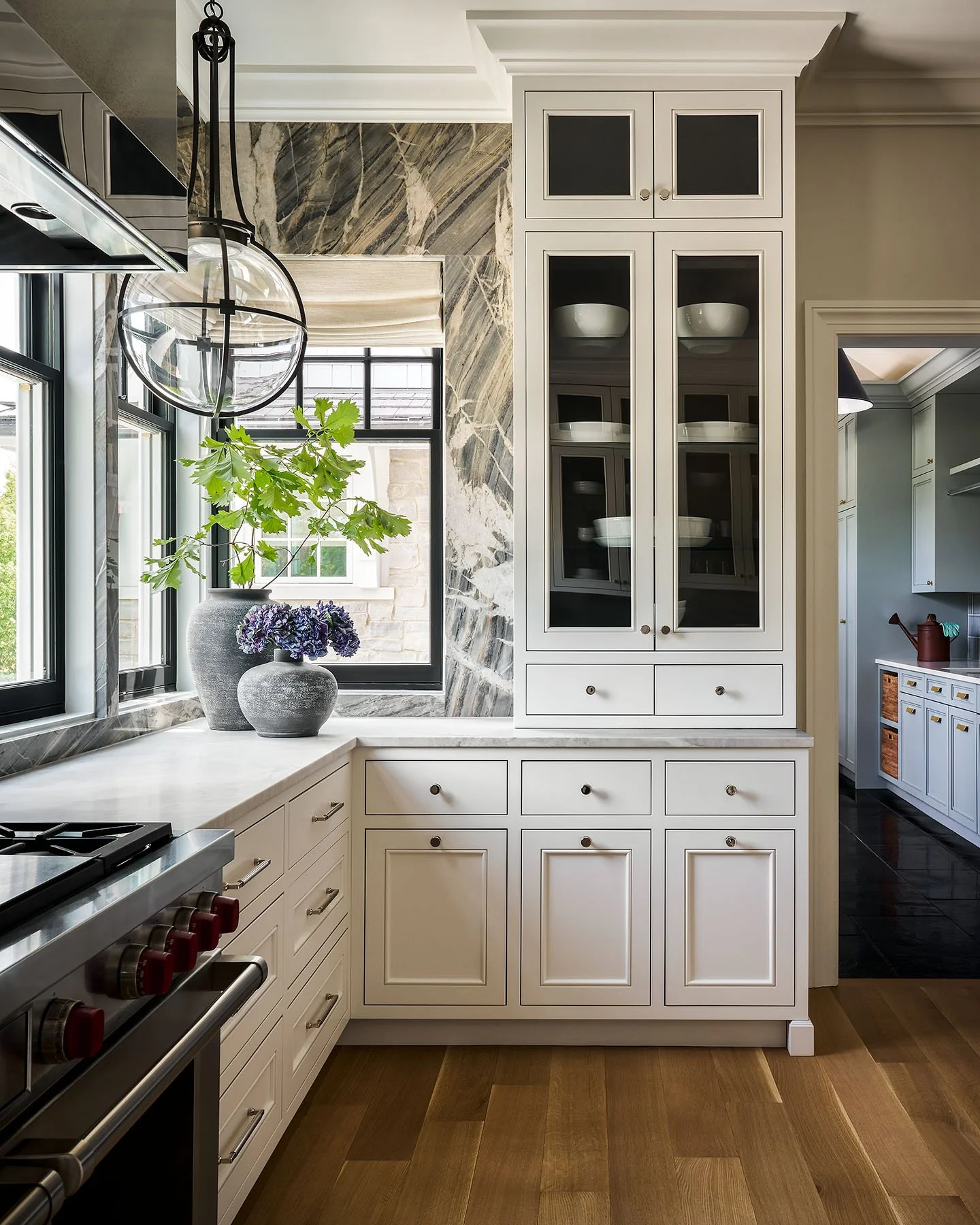 Custom white cabinetry with marble backsplash and brass hardware in Kenilworth luxury kitchen.