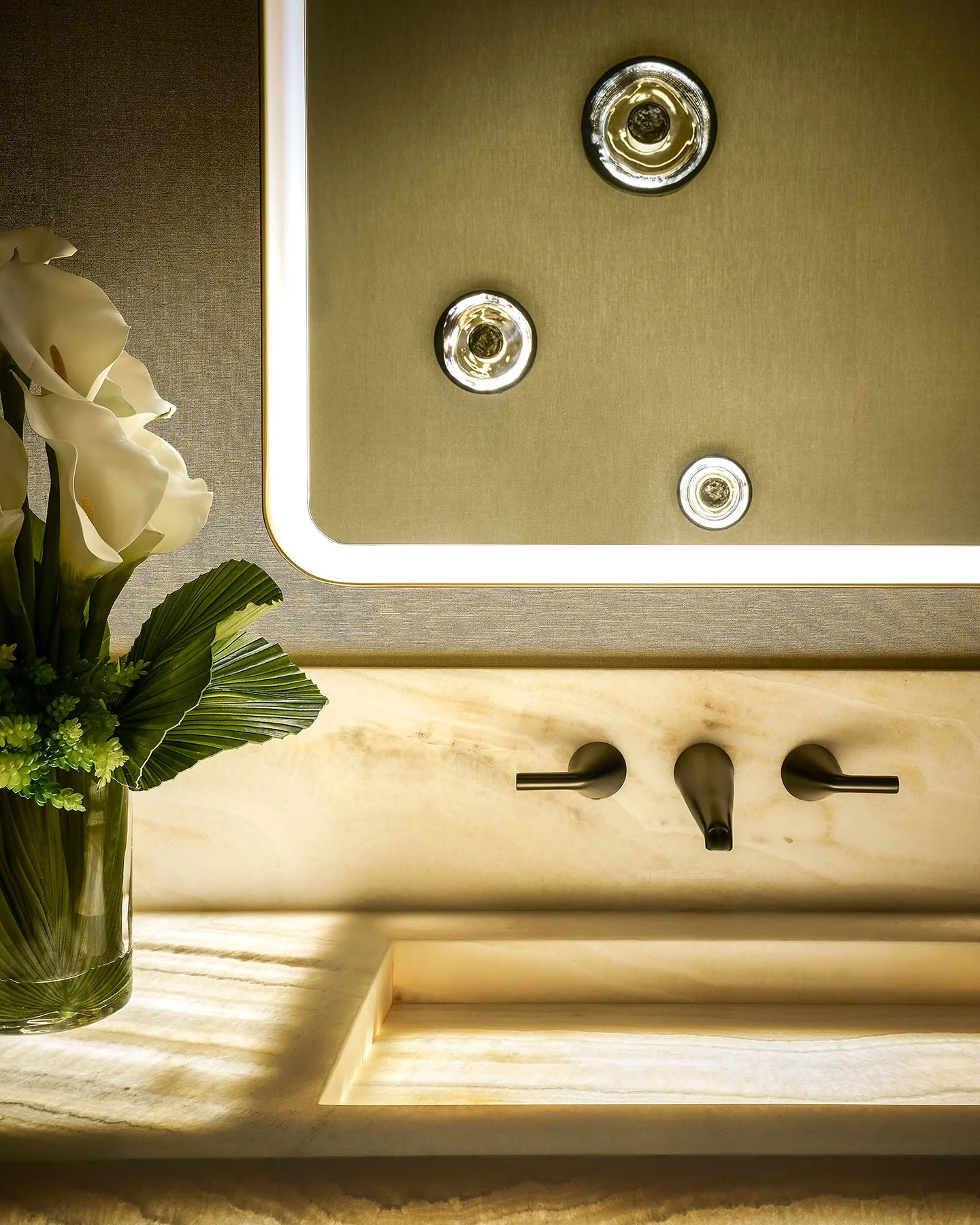 Luxury closet with custom shelving, framed artwork, display lighting, and neutral modern finishes.