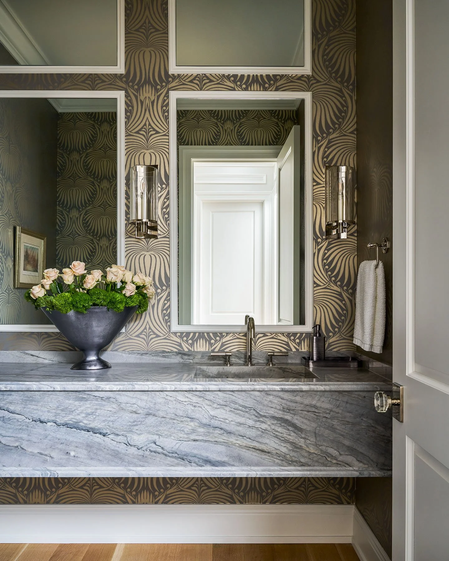 Powder room with marble floating vanity, patterned wallpaper, and chrome sconces in luxury Kenilworth interior.