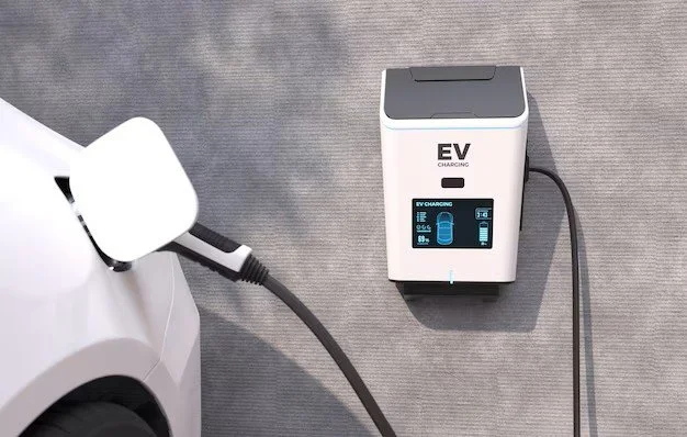 Electric vehicle charging station connected to an electric car with a charging cable.