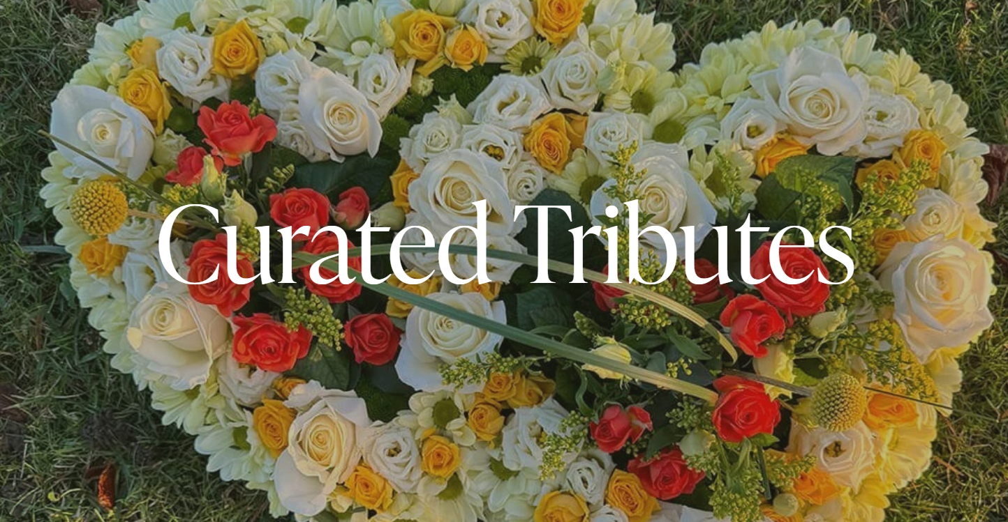 A heart-shaped arrangement of white, yellow, and red roses on grass, with the words 'Curated Tributes' overlayed.