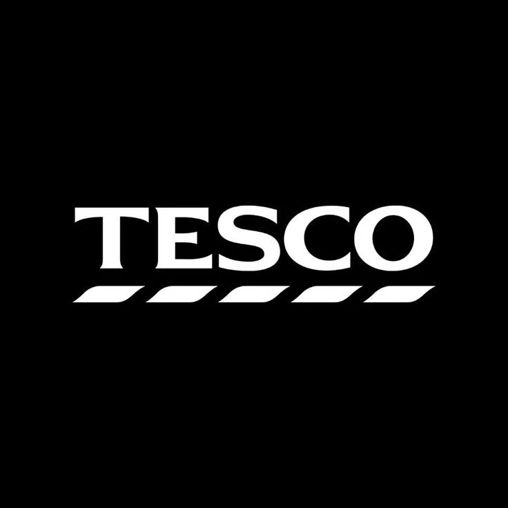 A black background with the white logo and text for Tesco, a grocery retail chain.