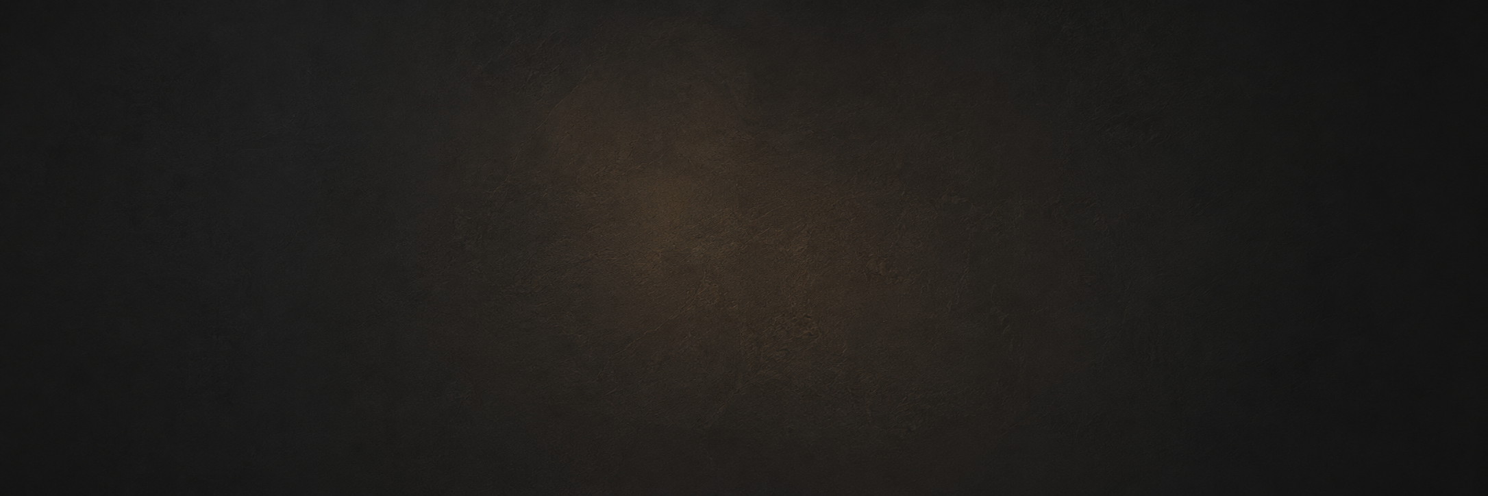 A dark, textured surface with a gradient of black and brown tones.