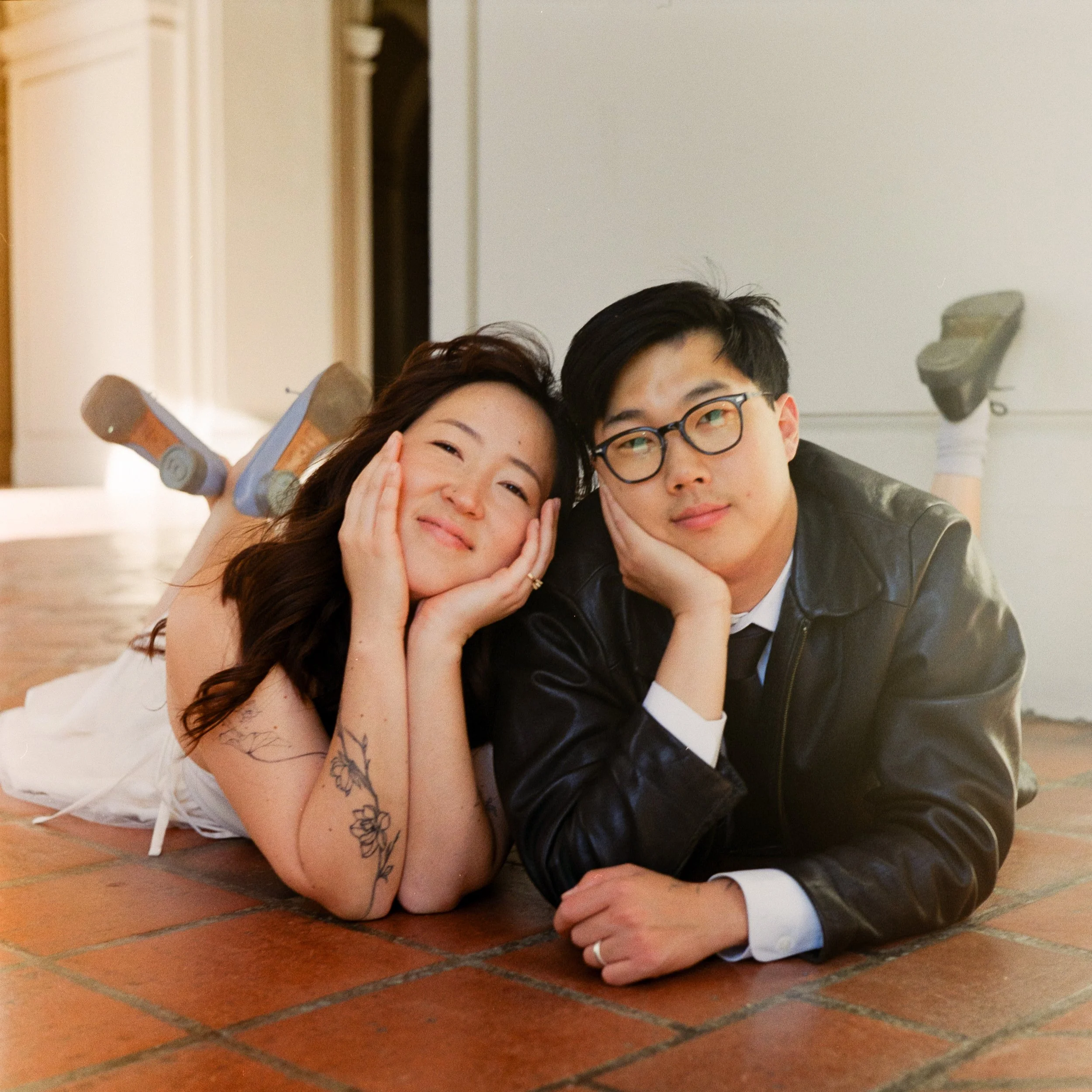 young Korean American engaged couple laying on floor